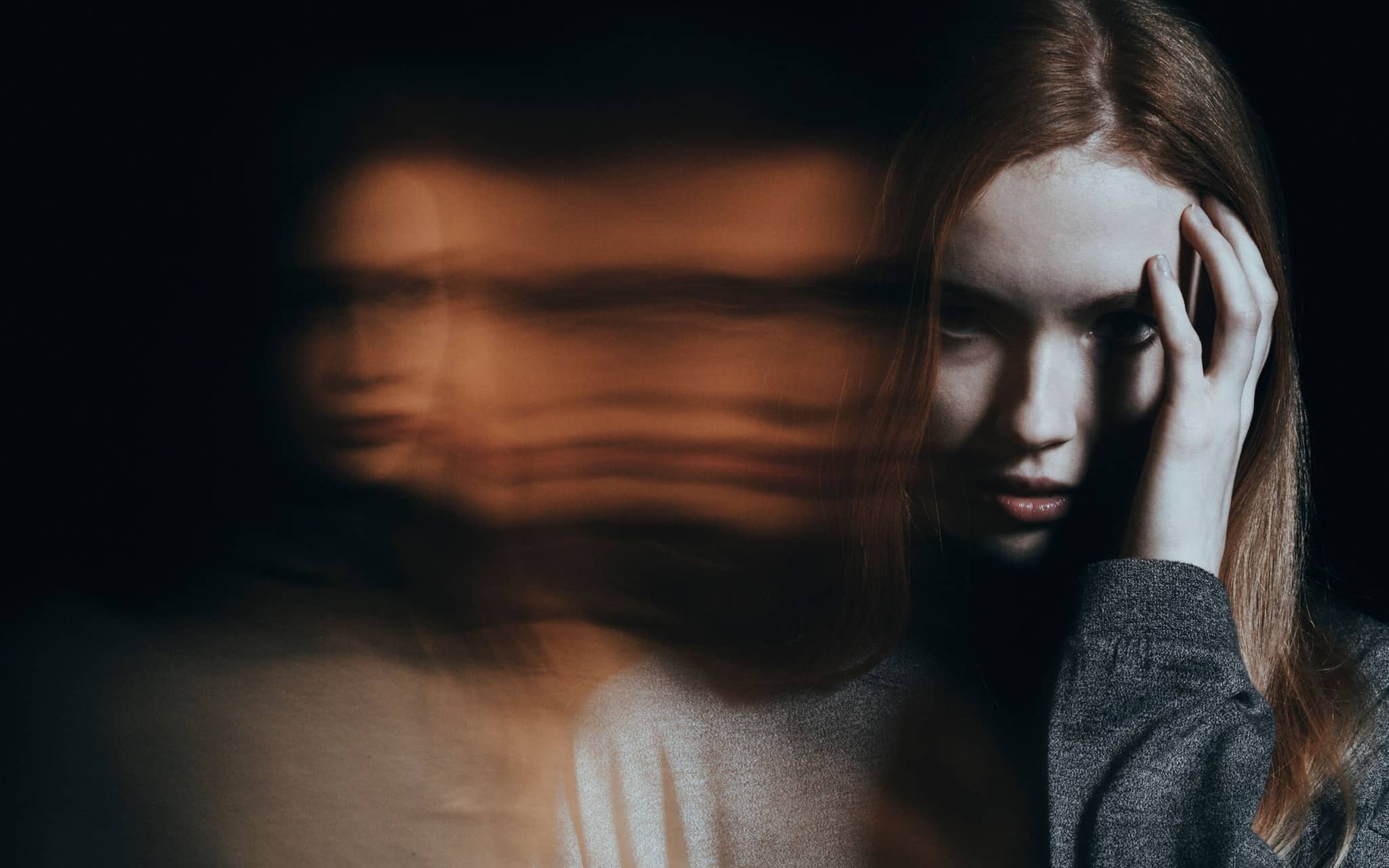 Adipositas: Ein kleiner Junge liegt auf dem Sofa und isst einen Hamburger und Pommes Frites.