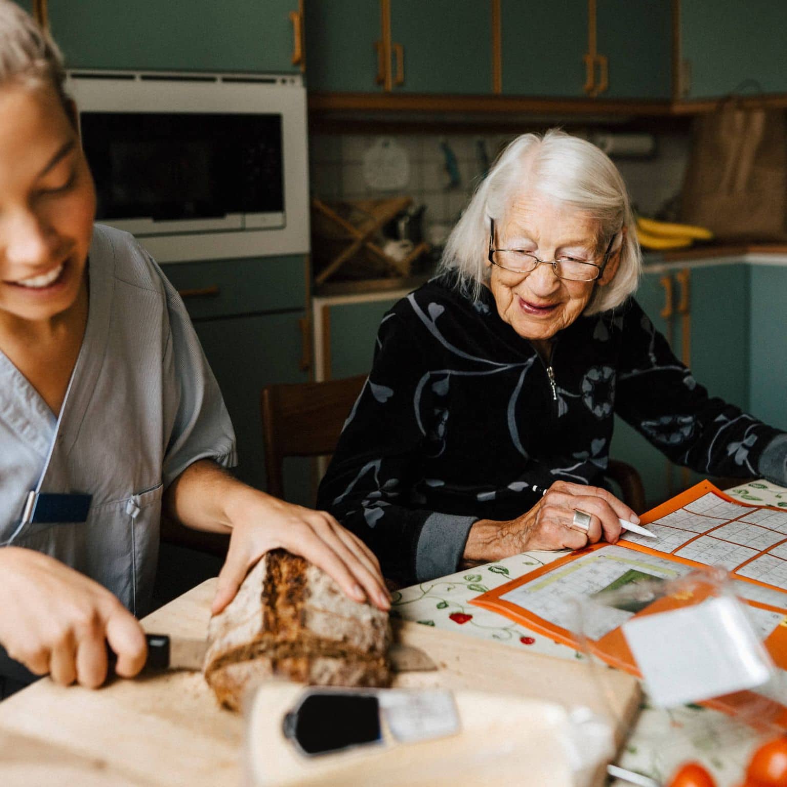 Azubi in der Pflege bei einer älteren Frau zuhause.