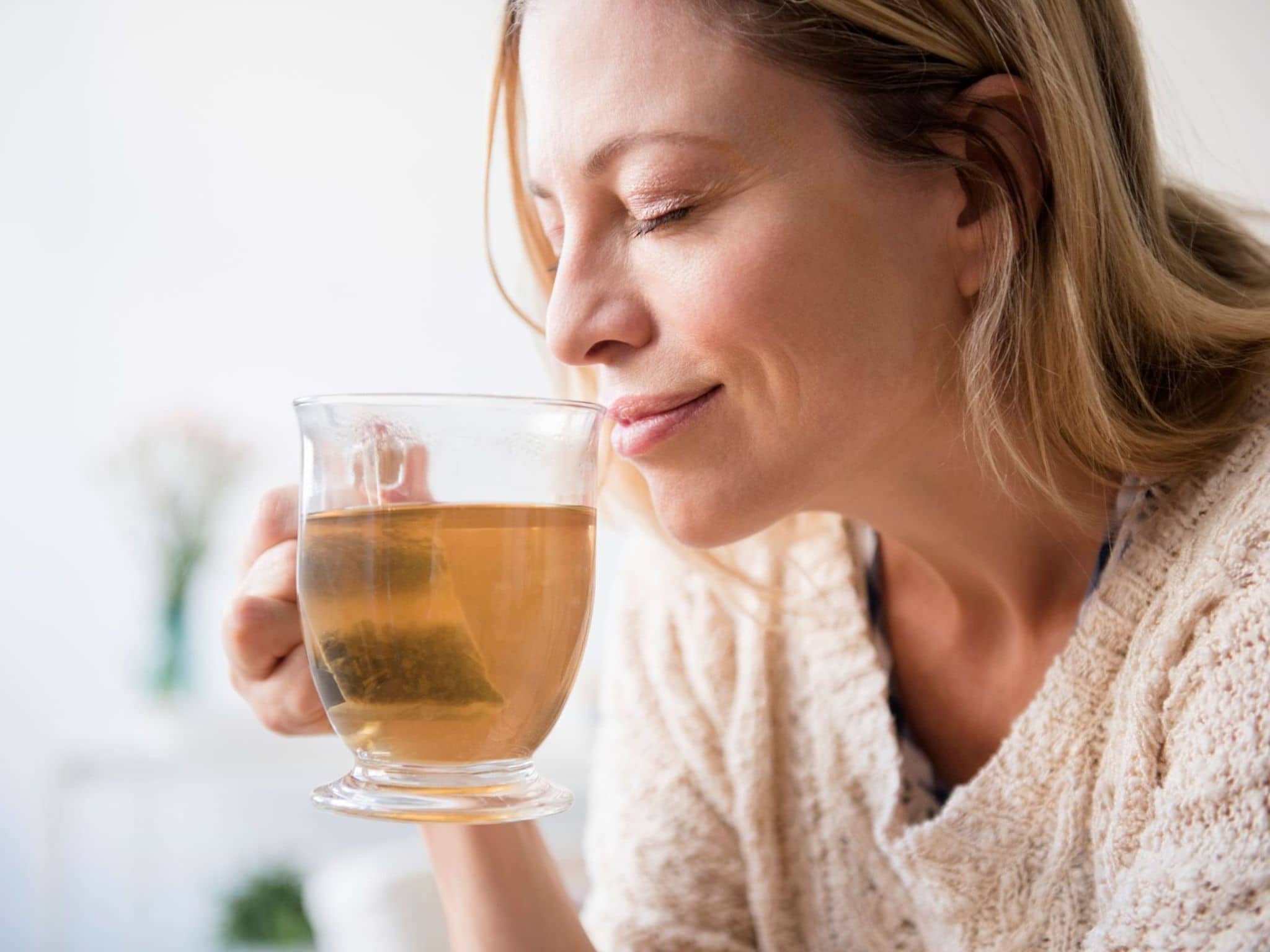Eine Frau trinkt einen Tee - ein bewährtes Hausmittel gegen Schnupfen