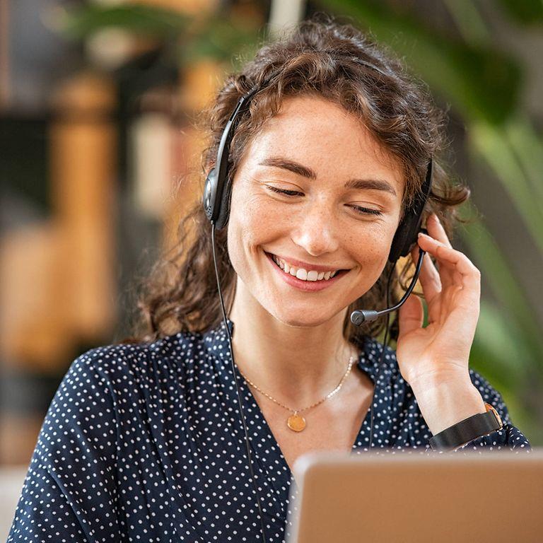Bild: Lächelnde Frau im Call Center mit Headset