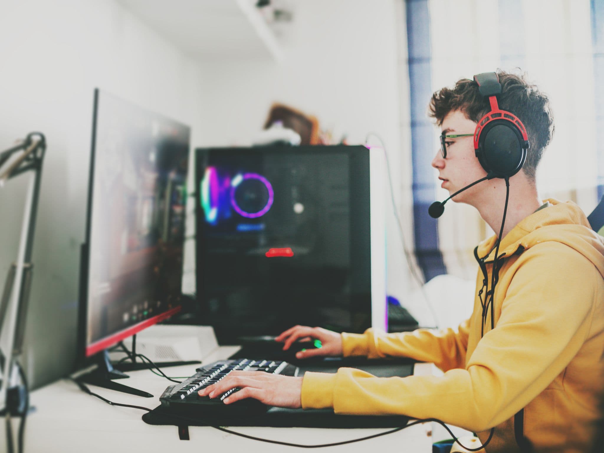 Bild: Teenager mit Headset spielt an einem Computer