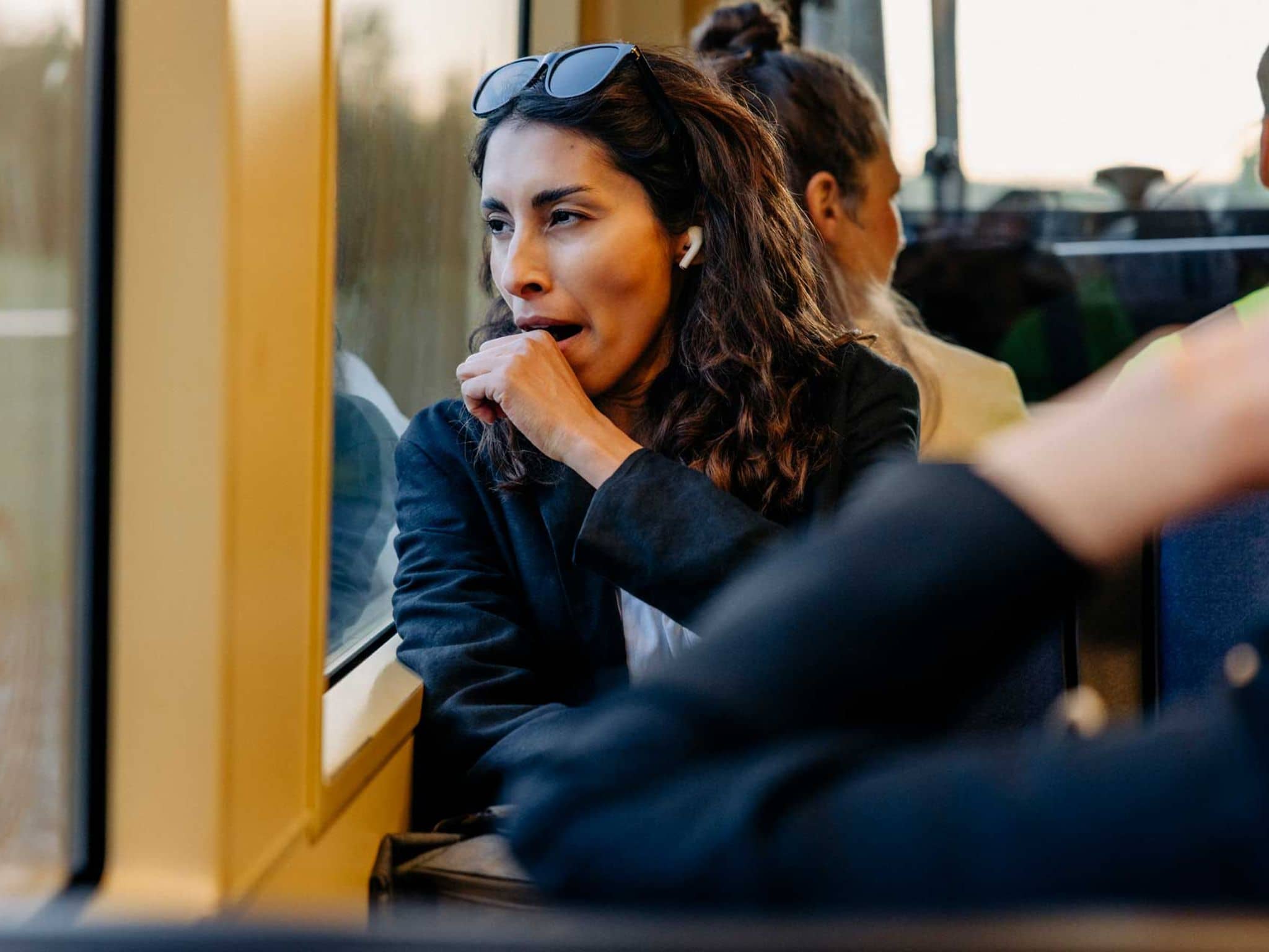 Symbolbild ständig müde: Müde Frau gähnt auf dem Weg zur Arbeit