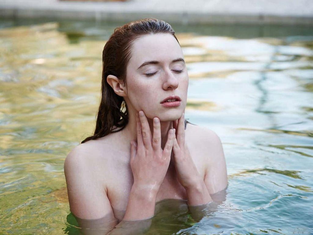 Anthroposophische Medizin: Frau badet entspannt in einem Gewässer