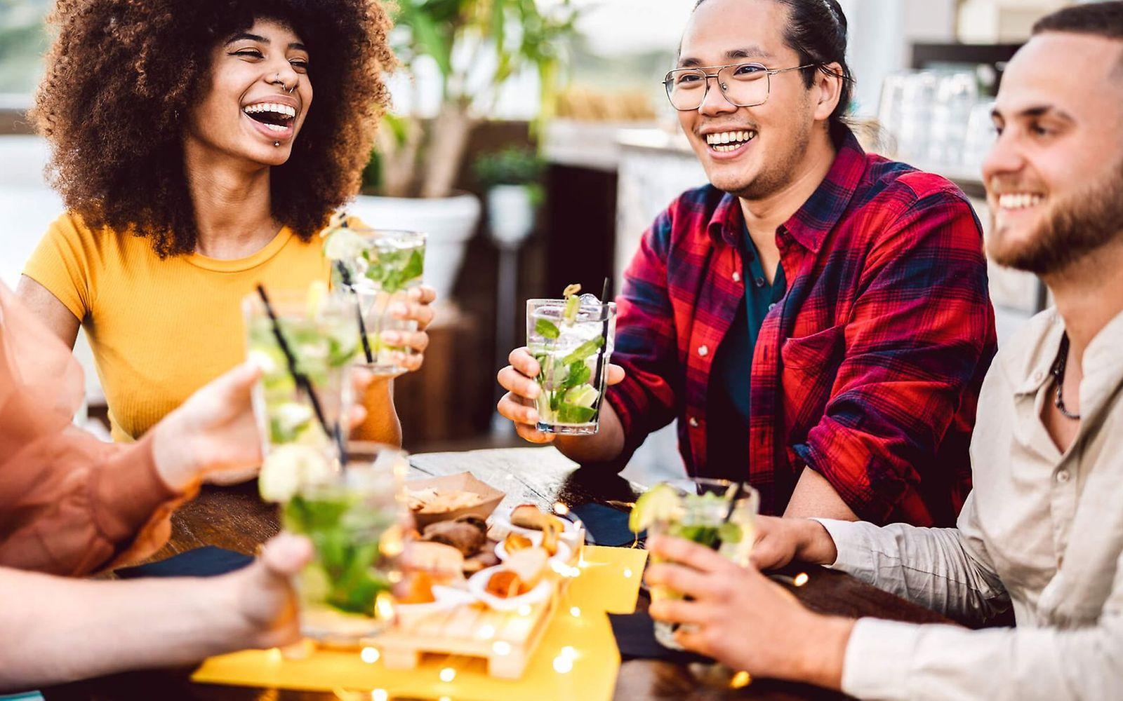 Alkoholfrei leben: Junge Leute sitzen zusammen und trinken alkoholfreie Mocktails.