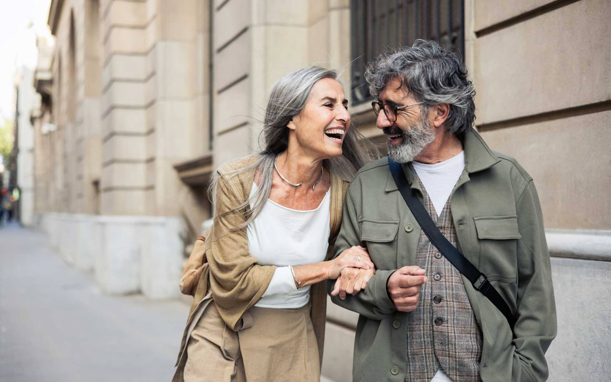 Ein älteres Paar spaziert lachend durch die Stadt