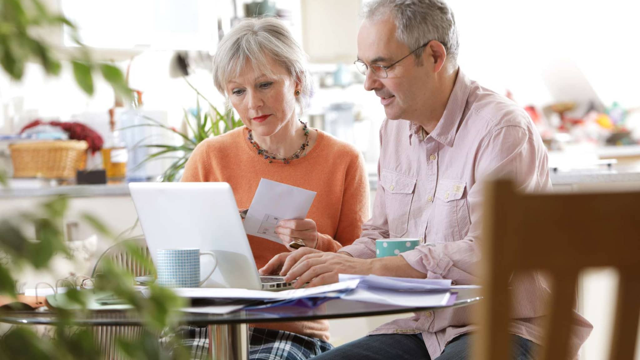 Widerspruchsverfahren: Ein älteres Paar schaut zuhause gemeinsam auf den Monitor eines Notebooks.