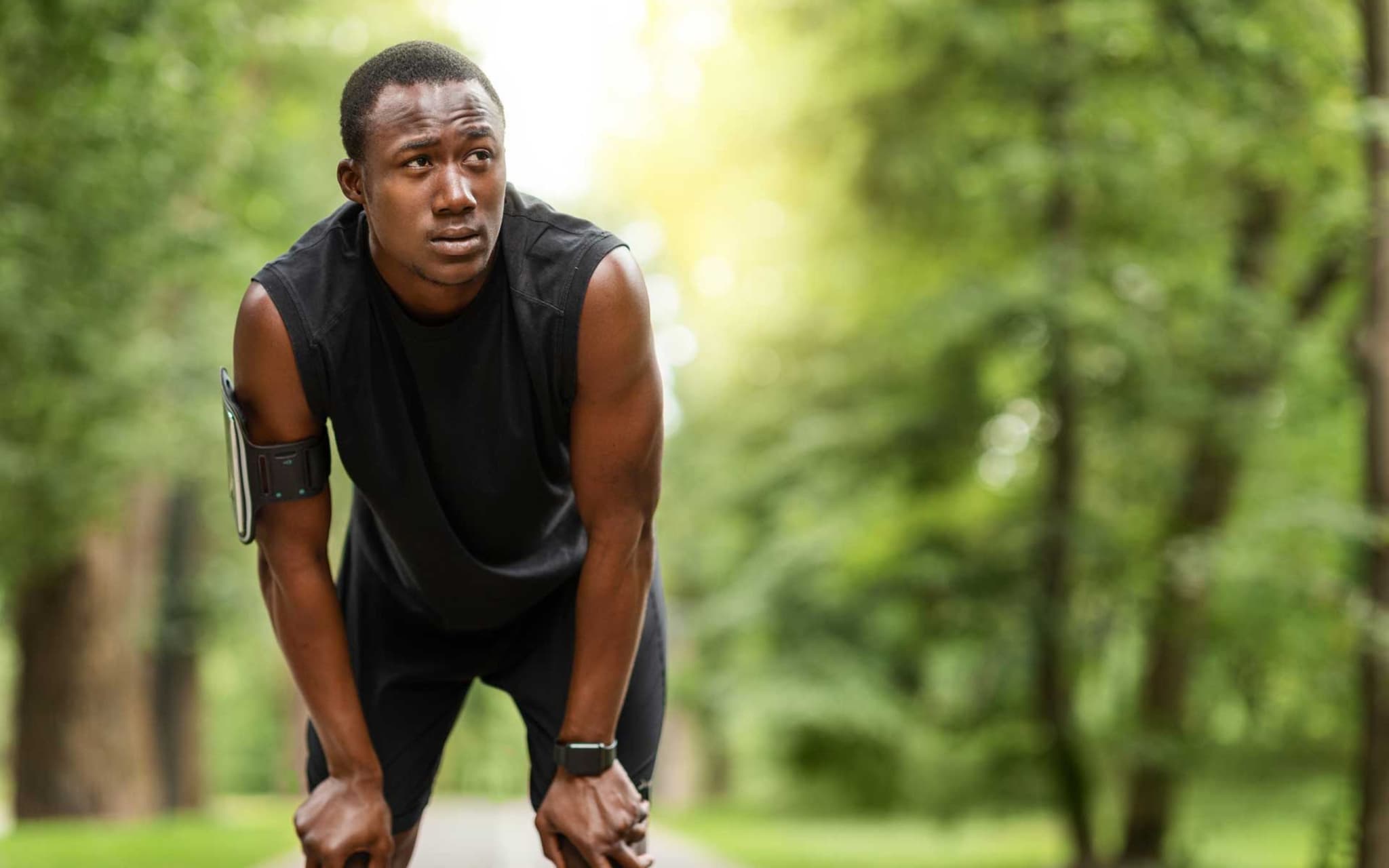 Herzfrequenzvariabilität: Junger Mann hält erschöpft im Lauf inne