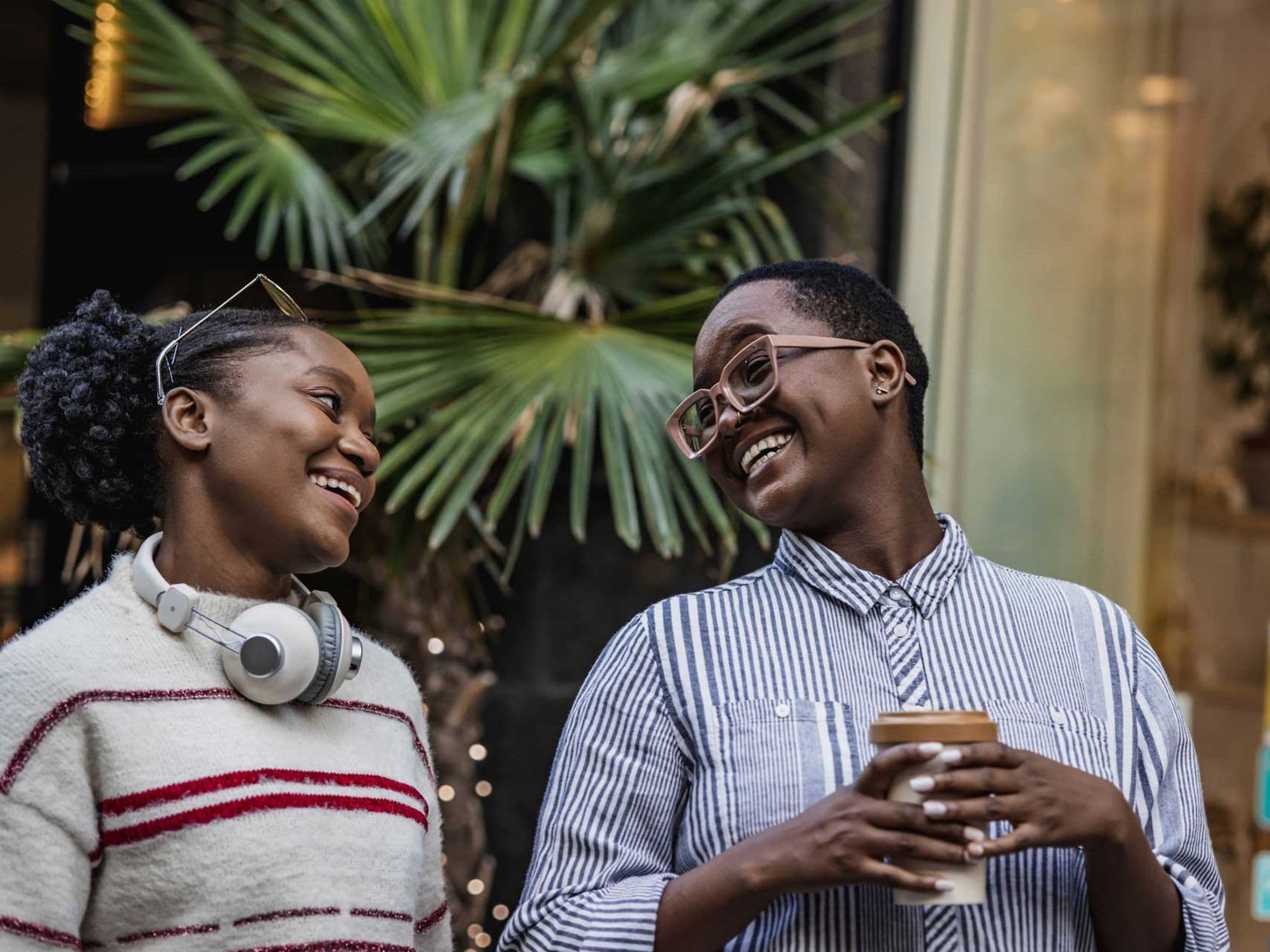 Junge Frau freut sich über das Kompliment ihrer Freundin