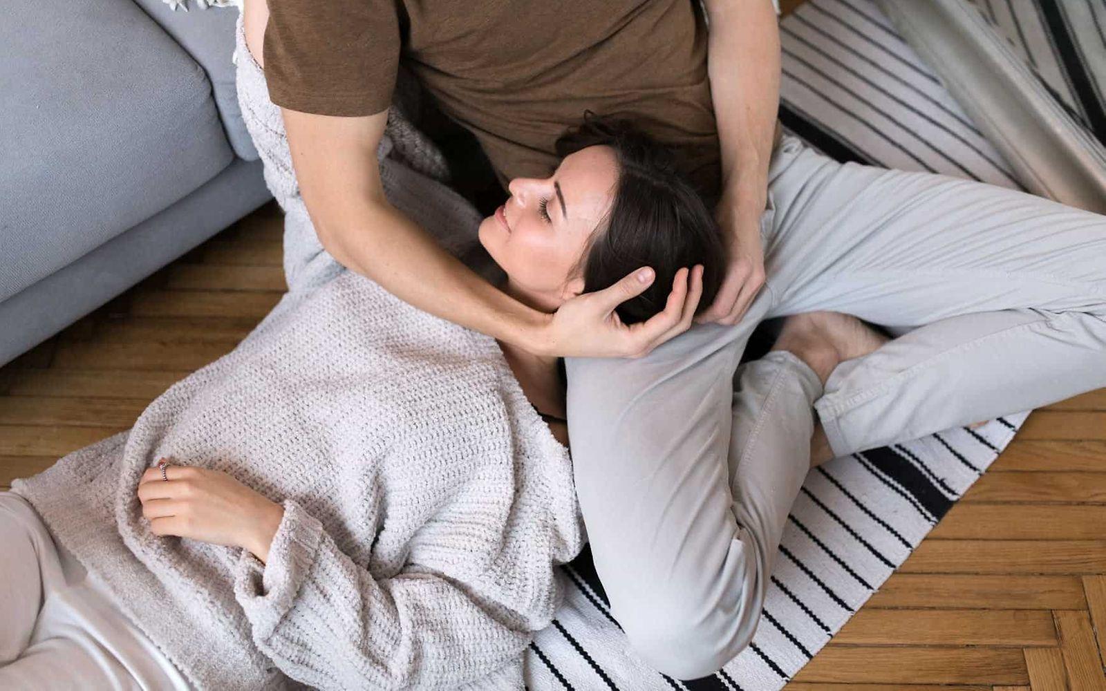 Symbolbild Stressbewältigungstraining: Frau liegt entspannt auf dem Schoß ihres Mannes.