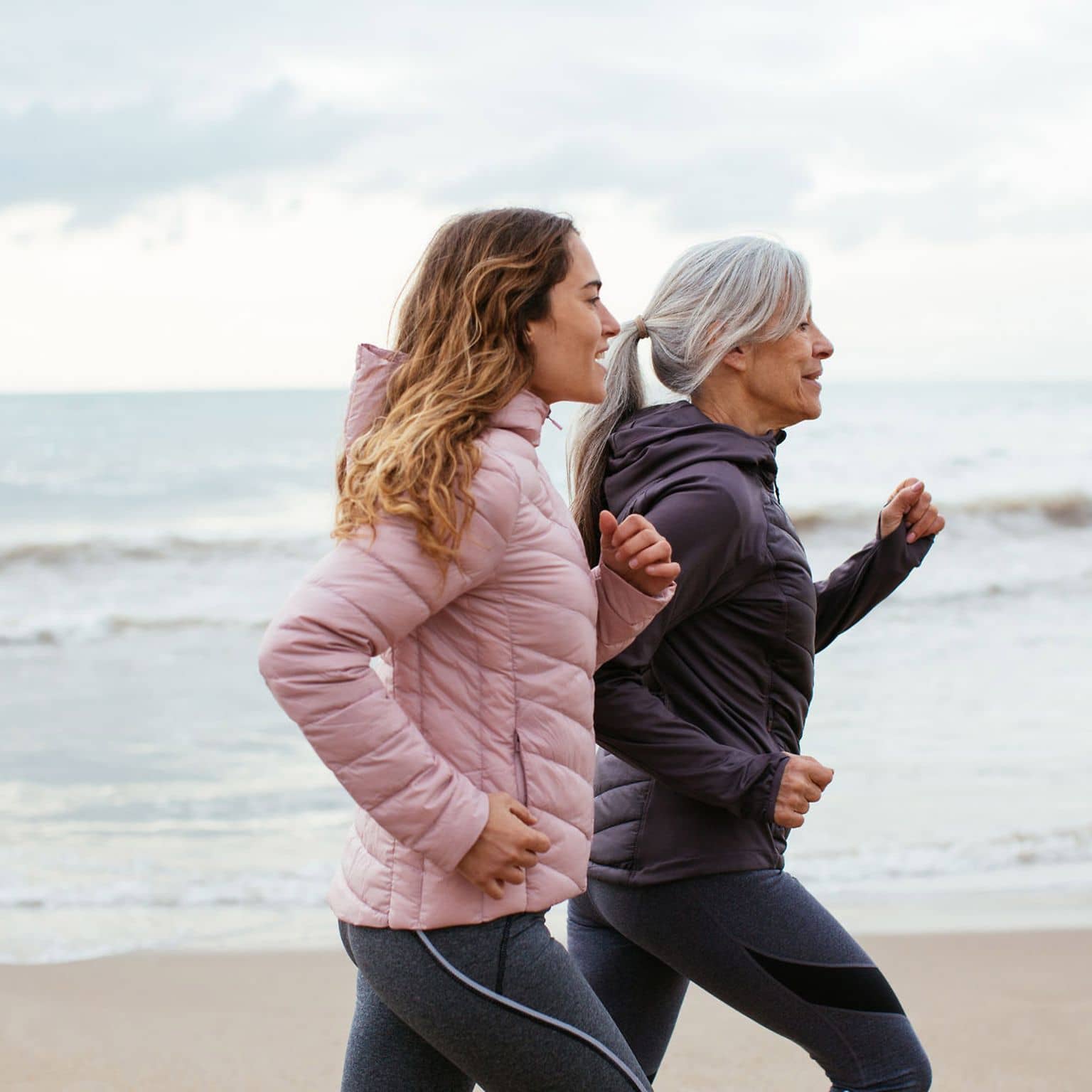 Ausdauertraining: Zwei Frauen joggen am Strand.