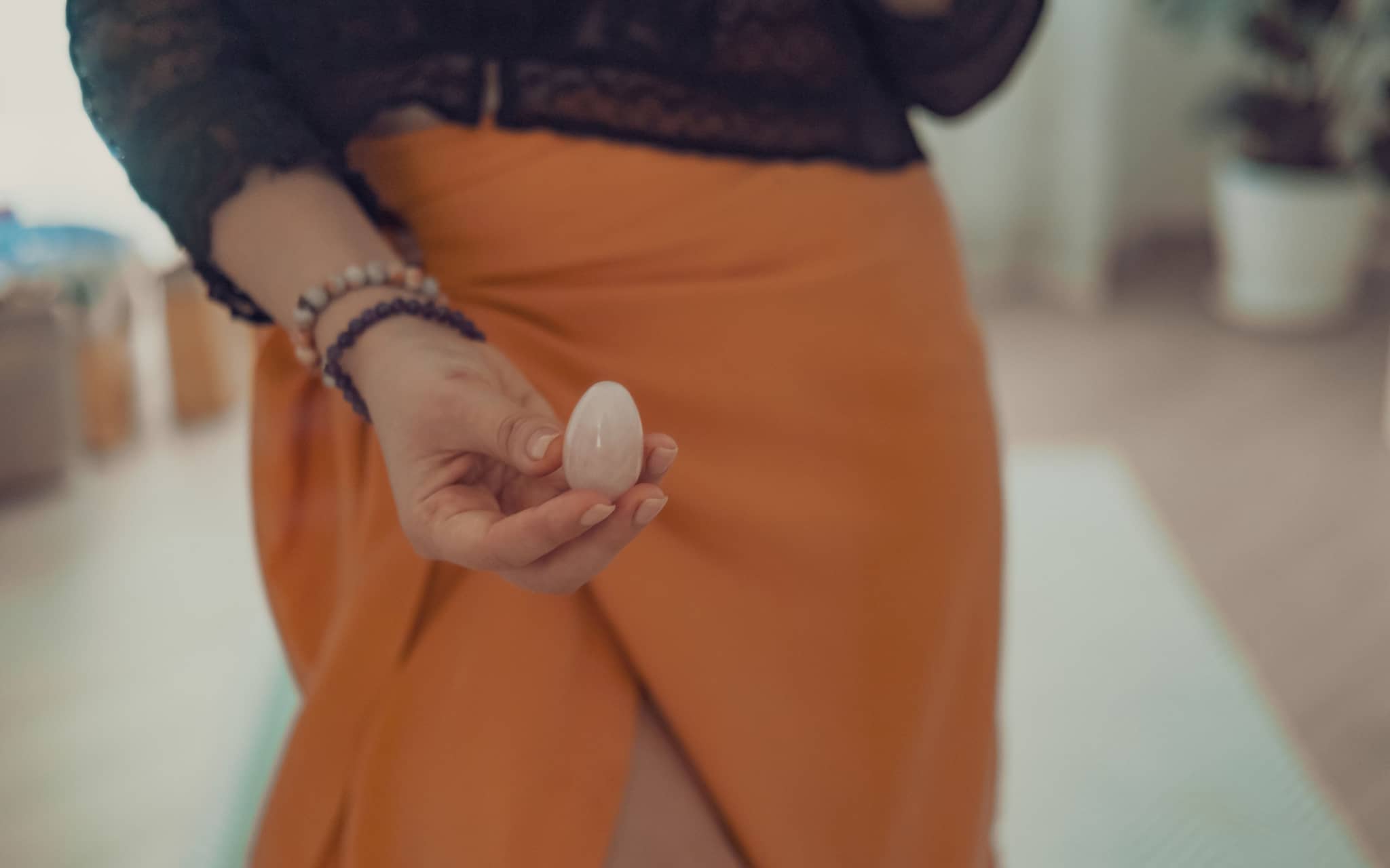 Yoni Ei: Eine Frau hält ein Yoni-Ei aus Rosenquarz in der Hand