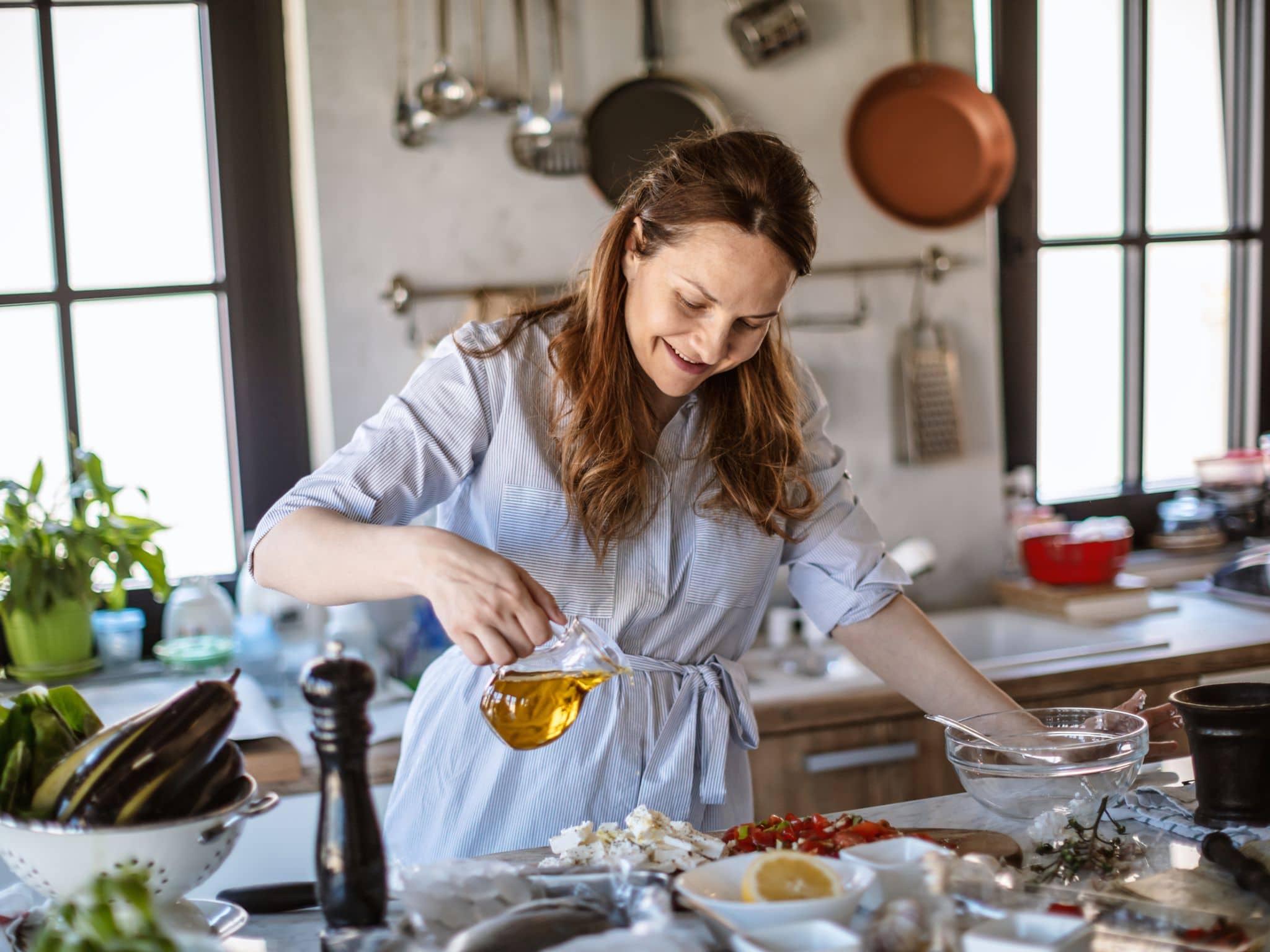 Schwarzkümmelöl: Eine Frau bereitet einen Salat mit Öl vor