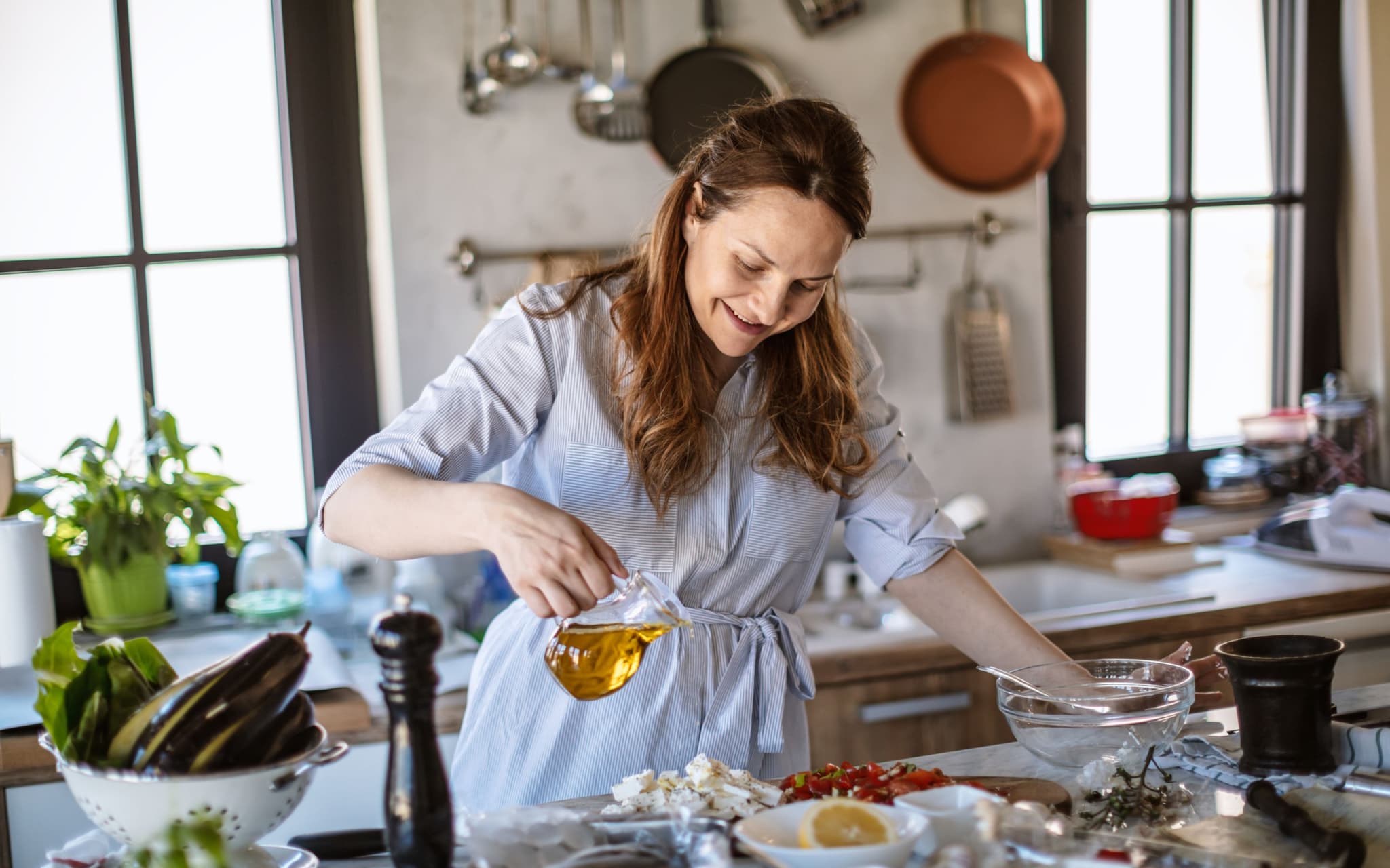 Schwarzkümmelöl: Eine Frau bereitet einen Salat mit Öl vor