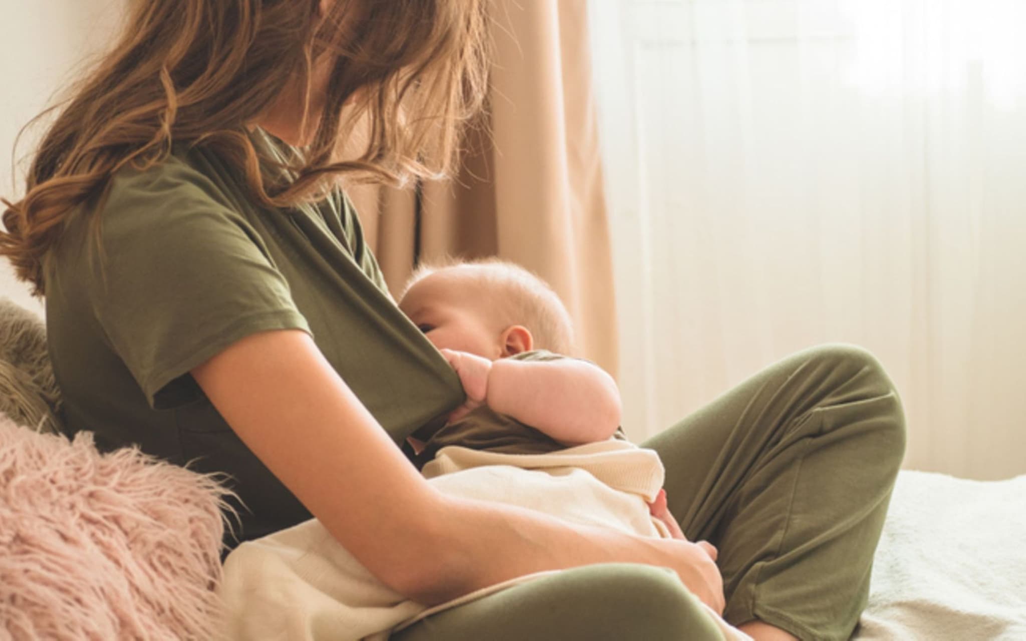 Muttermilch: Mutter schaut ihr Baby während des Stillens an