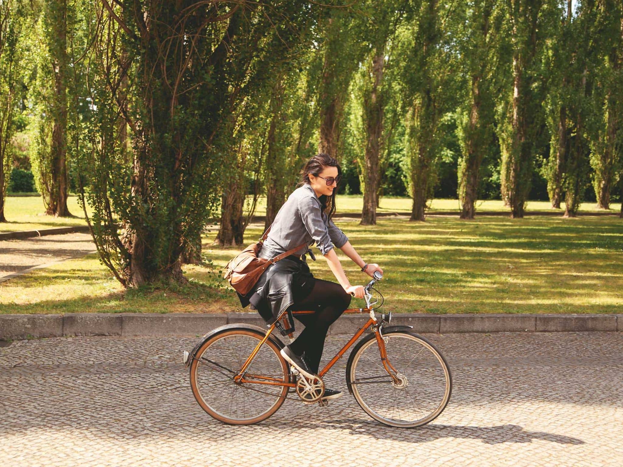Junge Frau genießt das Radfahren durch einen Park
