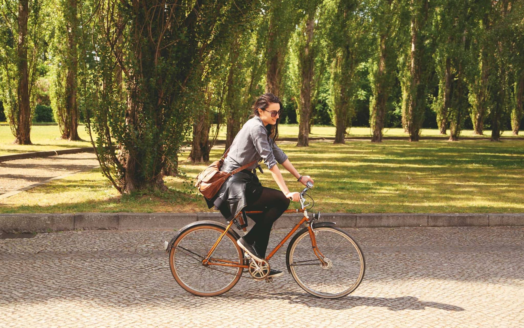 Junge Frau genießt das Radfahren durch einen Park