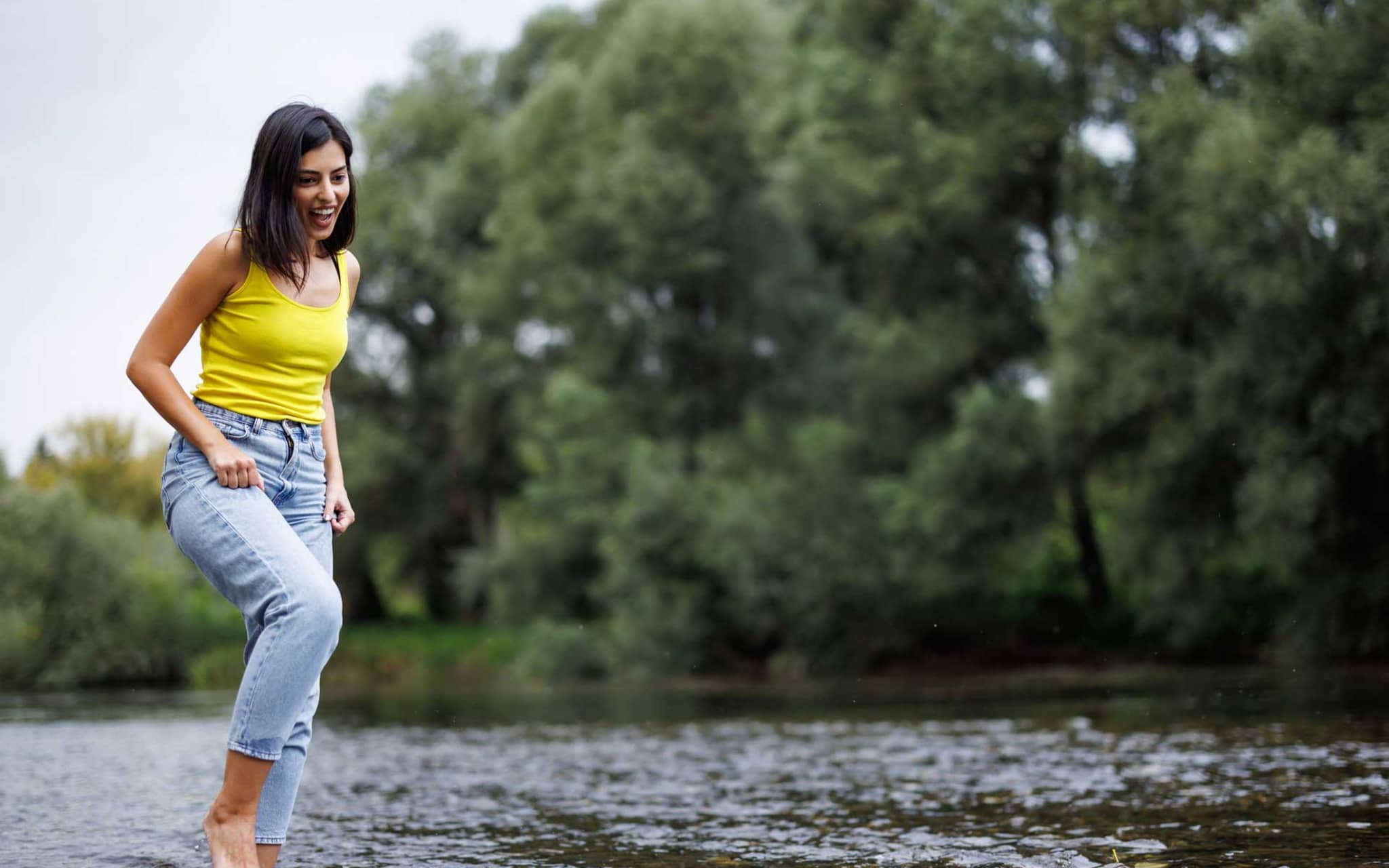 Junge Frau beim Kneippen in Natursee