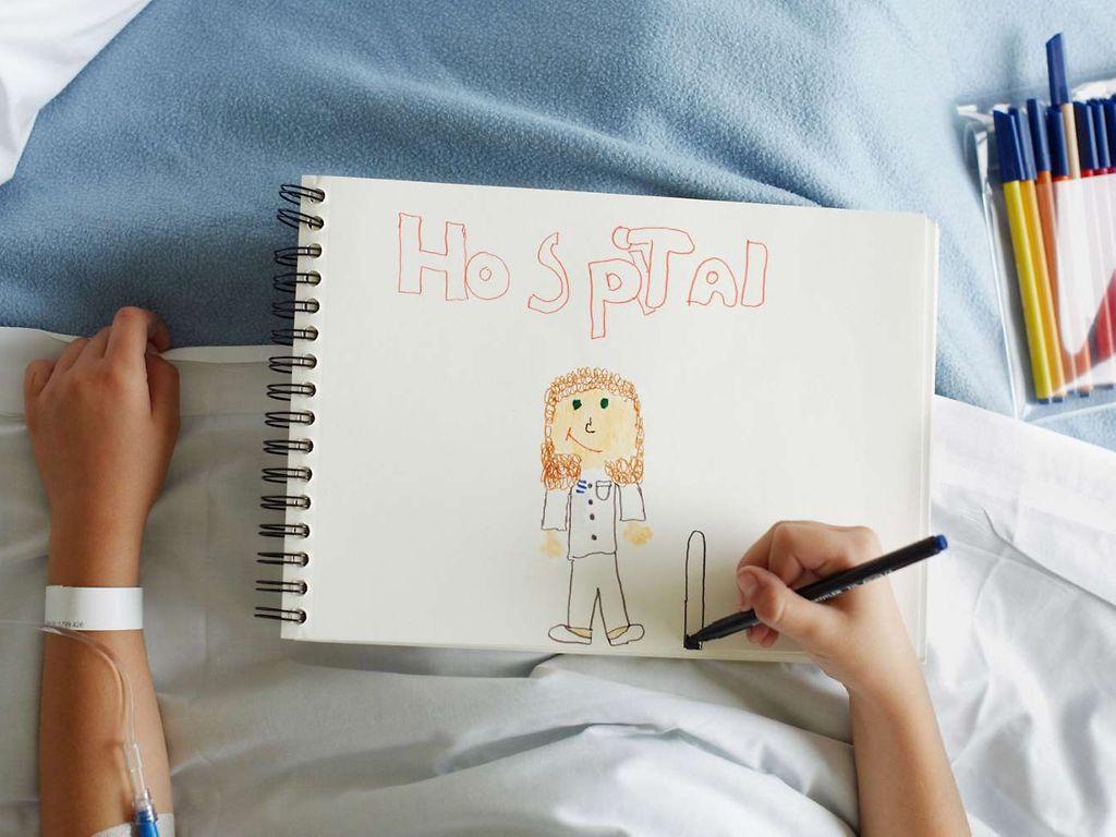 Krankenhausbehandlung: Kind malt Bild im Krankenhausbett.