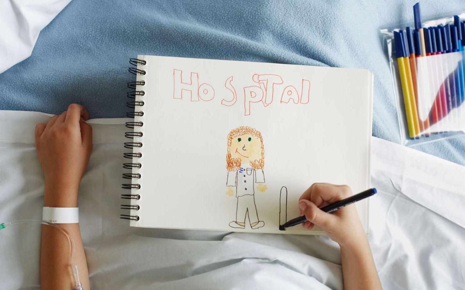 Krankenhausbehandlung: Kind malt Bild im Krankenhausbett.