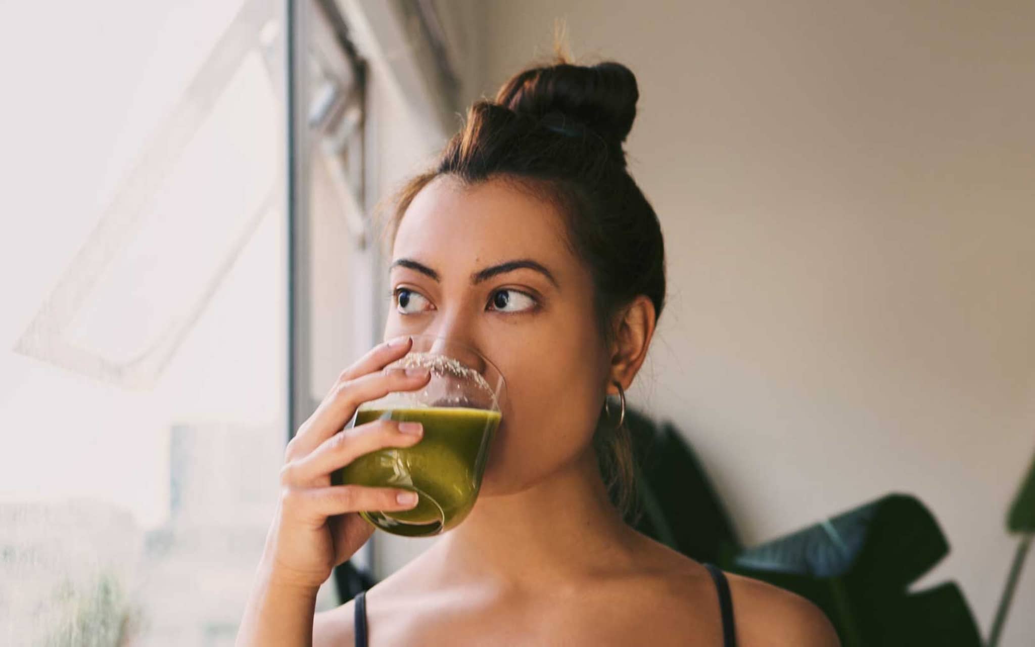Junge Frau trinkt Selleriesaft aus einem Glas