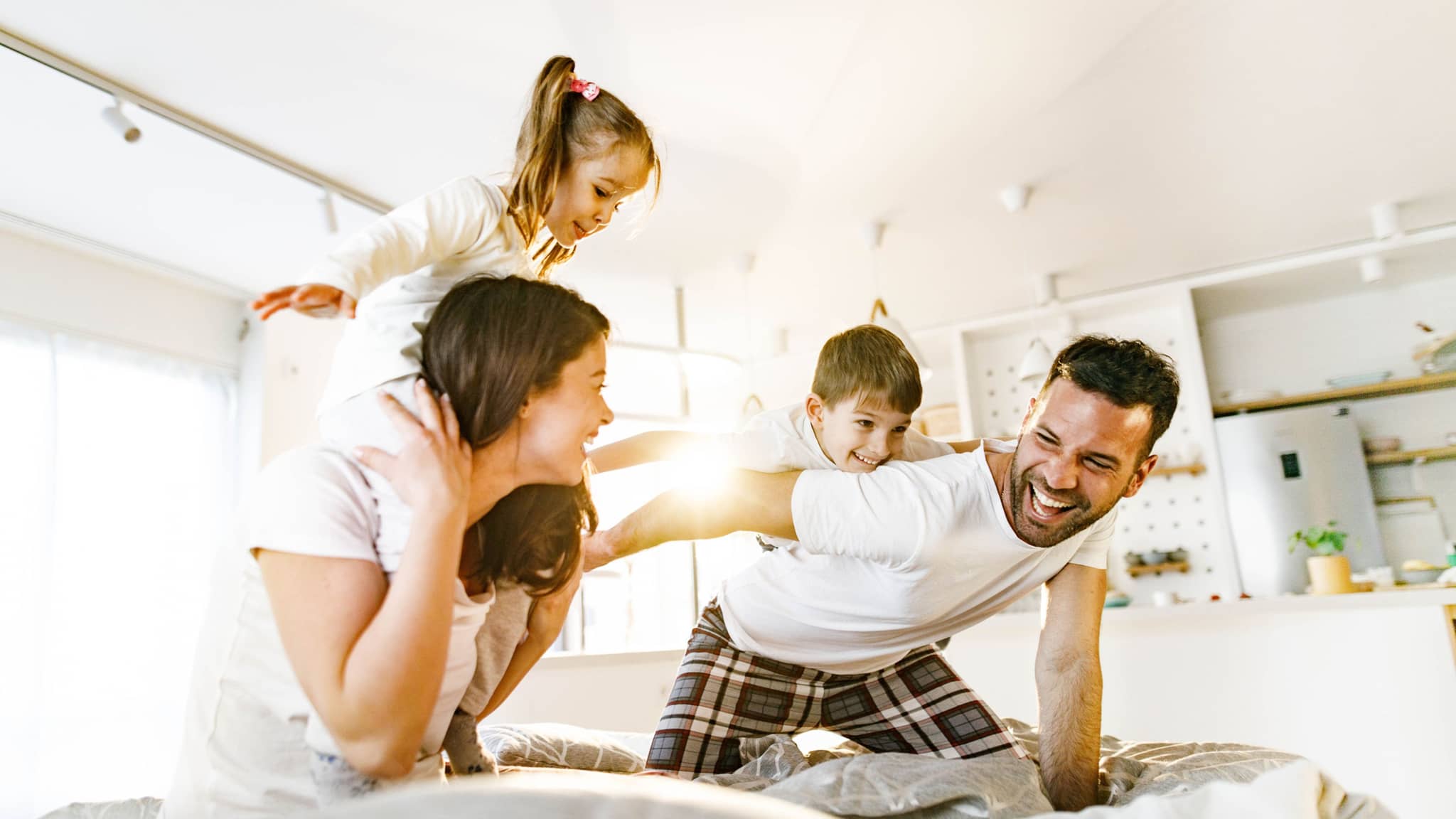 Unbeschwert mit der Familienversicherung. Eine Familie tobt herum.