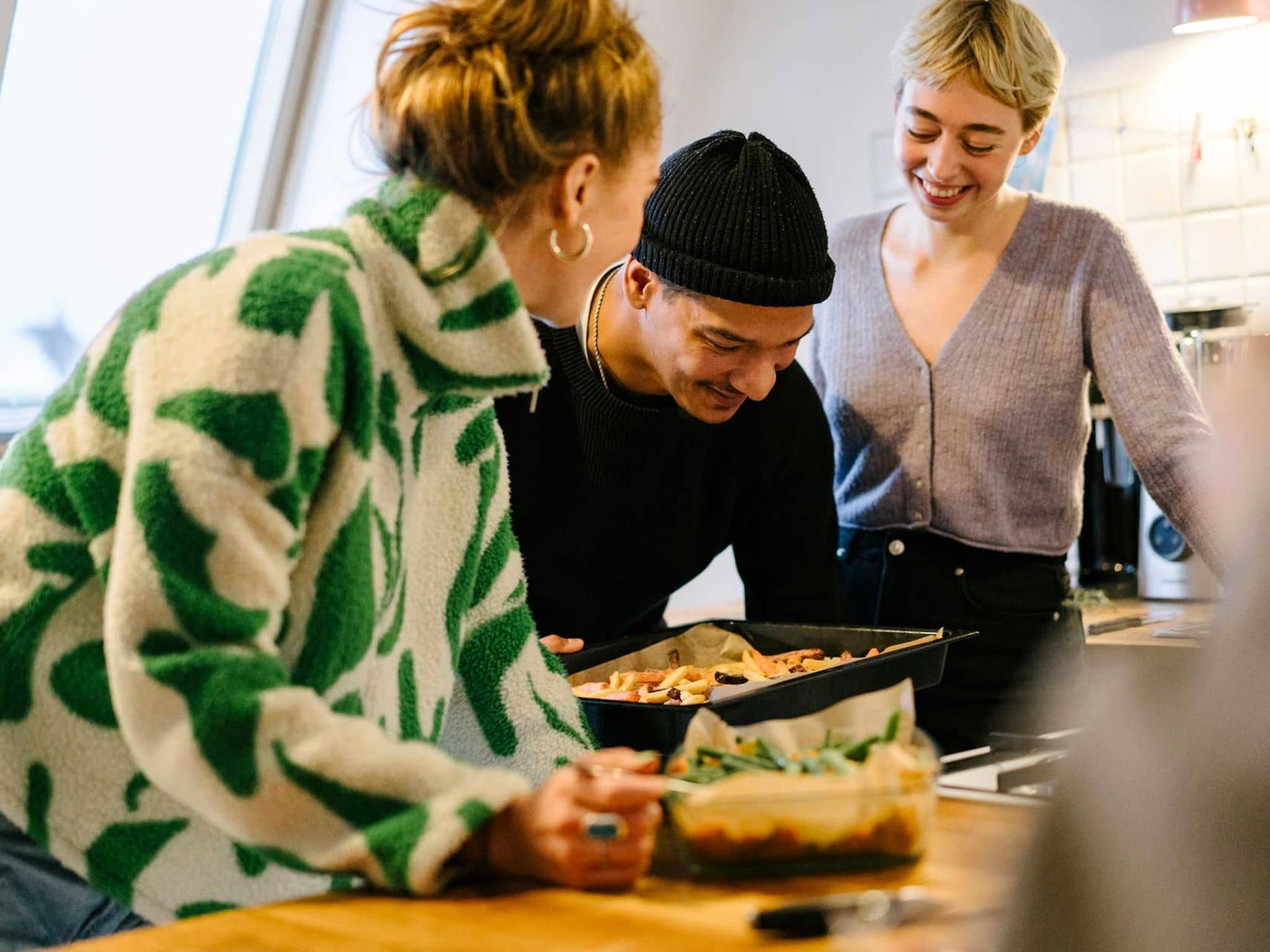 Change health insurance provider: Friends cook together and are happy about DAK membership.