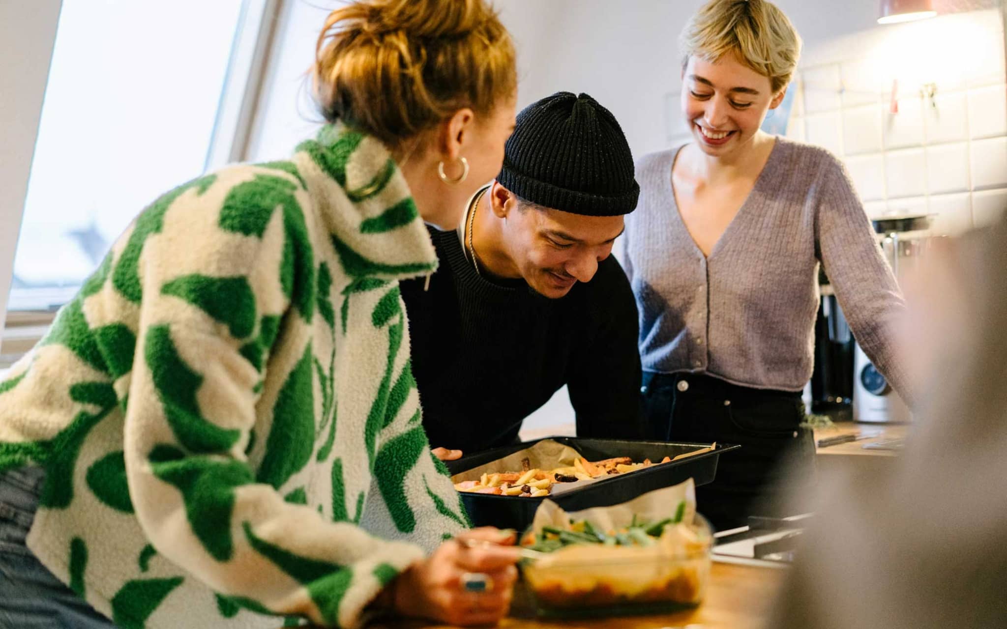 Change health insurance provider: Friends cook together and are happy about DAK membership.