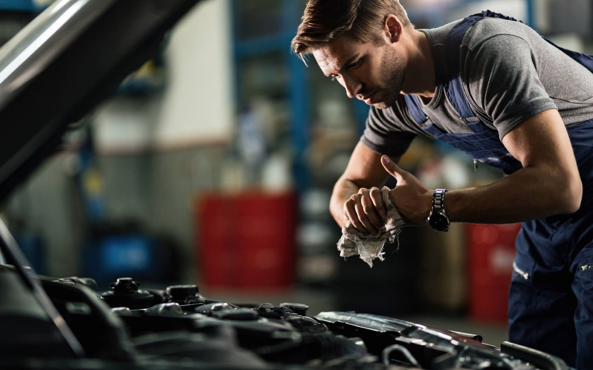 Auch während der Ausbildung braucht man eine Krankenversicherung: Kfz-Mechatroniker repariert ein Auto.