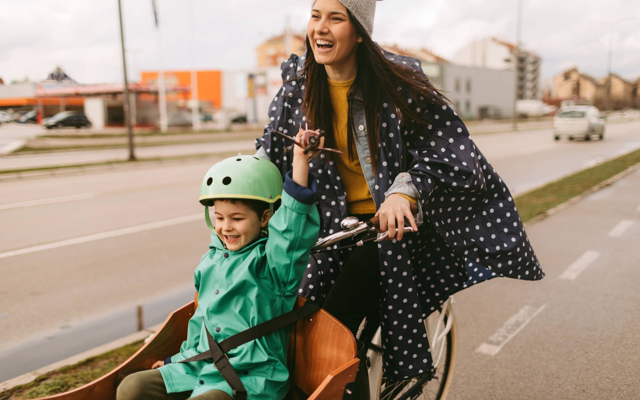Klimaschutz und Klimaretten: Eine Mutter fährt ihr Kind in einem Lastenrad
