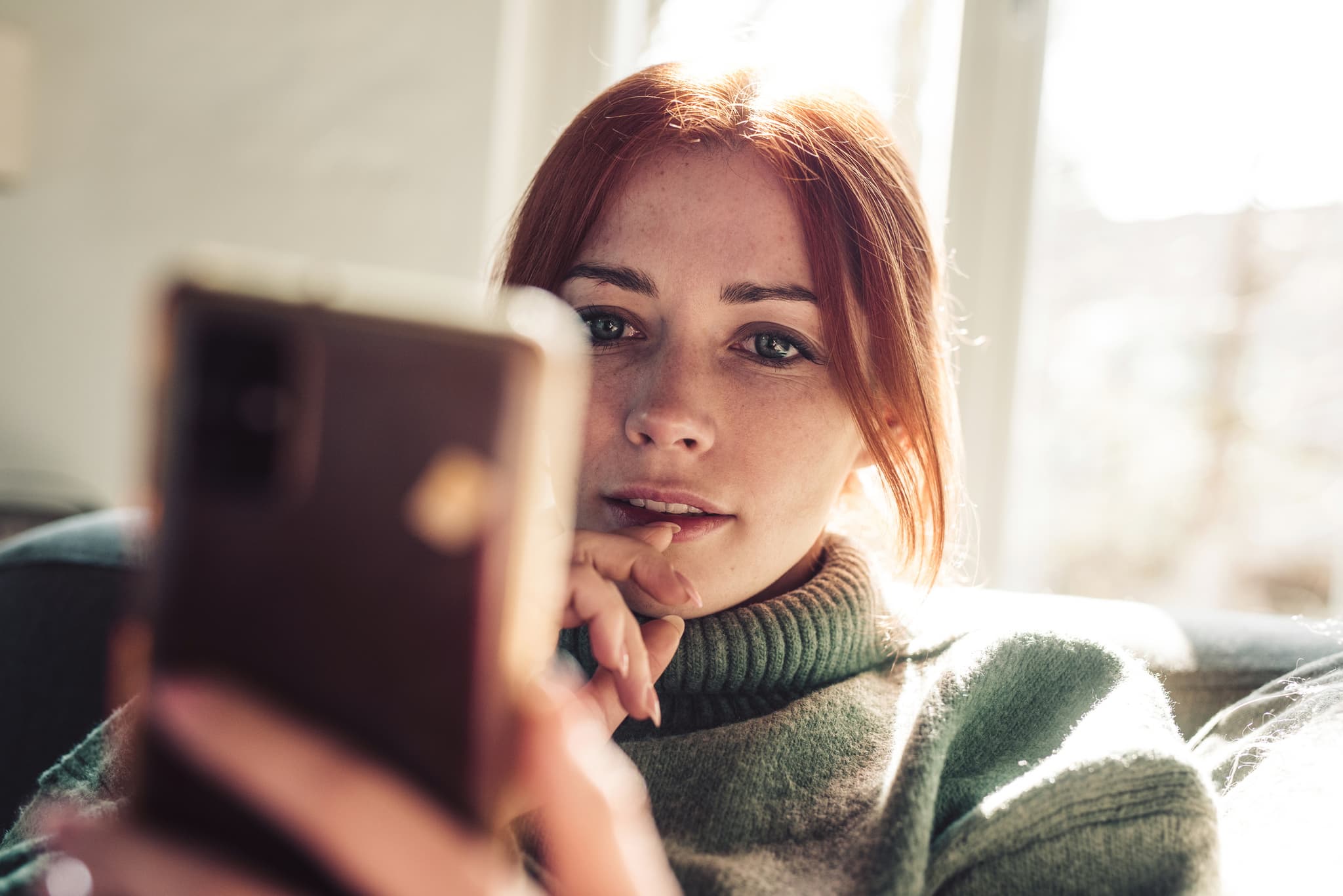 Frau vergleicht sich mit jemandem auf ihrem Smartphone