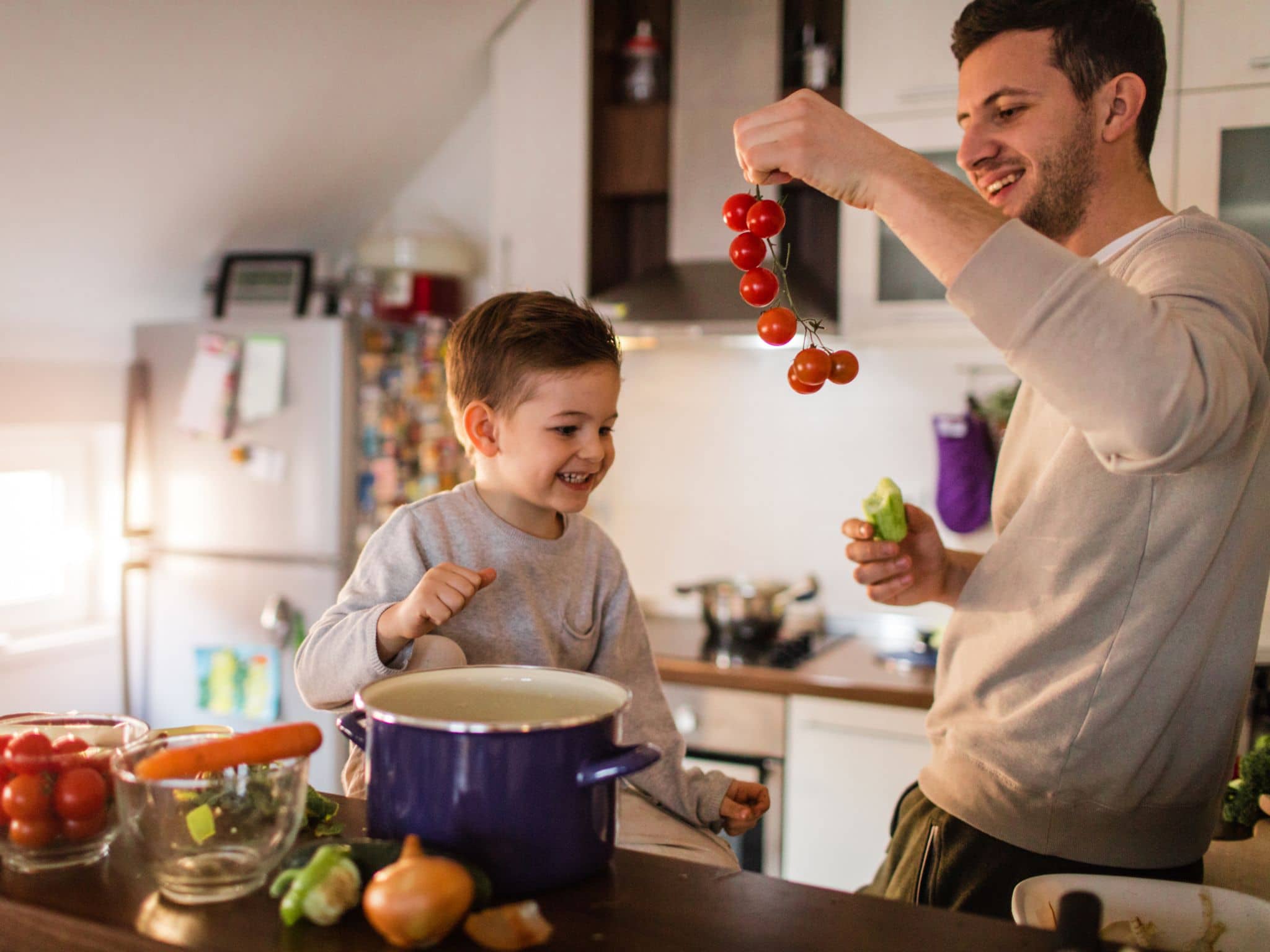 Gesunde Hausmannskost: Mann kocht gemeinsam mit kleinem Kind.