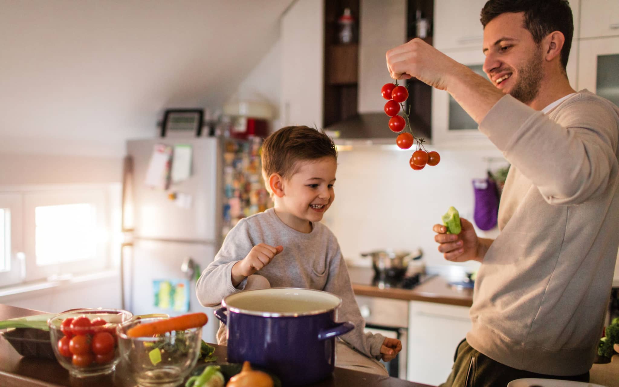 Gesunde Hausmannskost: Mann kocht gemeinsam mit kleinem Kind.