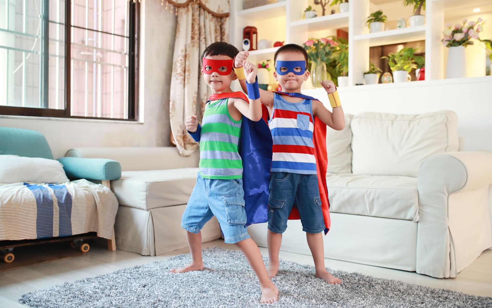 Indoor-Spiele: Zwei kleine verkleidete Jungs in einem Wohnzimmer.
