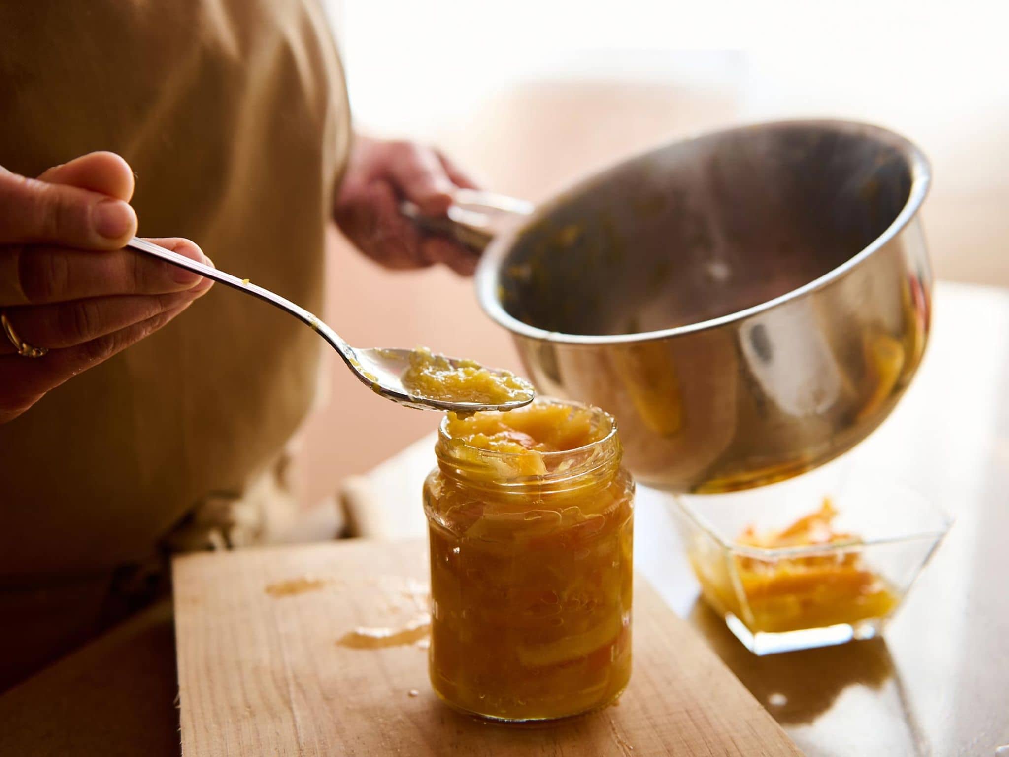 Eine Frau kocht herzhafte Marmelade in ihrer Küche ein.