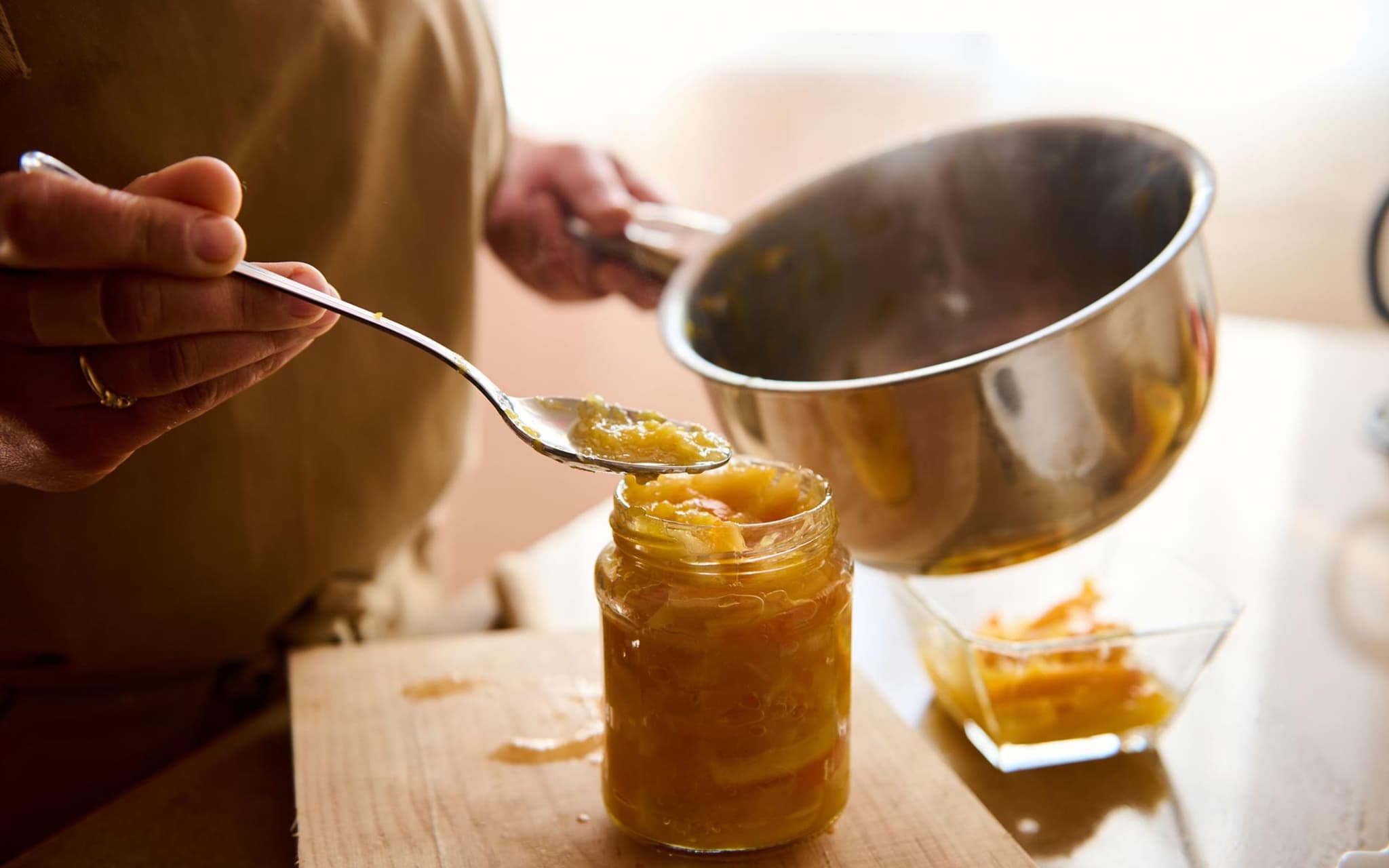 Eine Frau kocht herzhafte Marmelade in ihrer Küche ein.