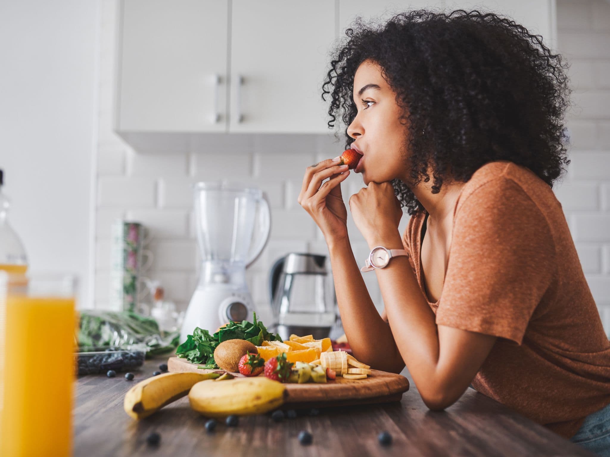 Eine Frau gönnt sich ein gesundes Frühstück bestehend aus viel Gemüse und Obst.