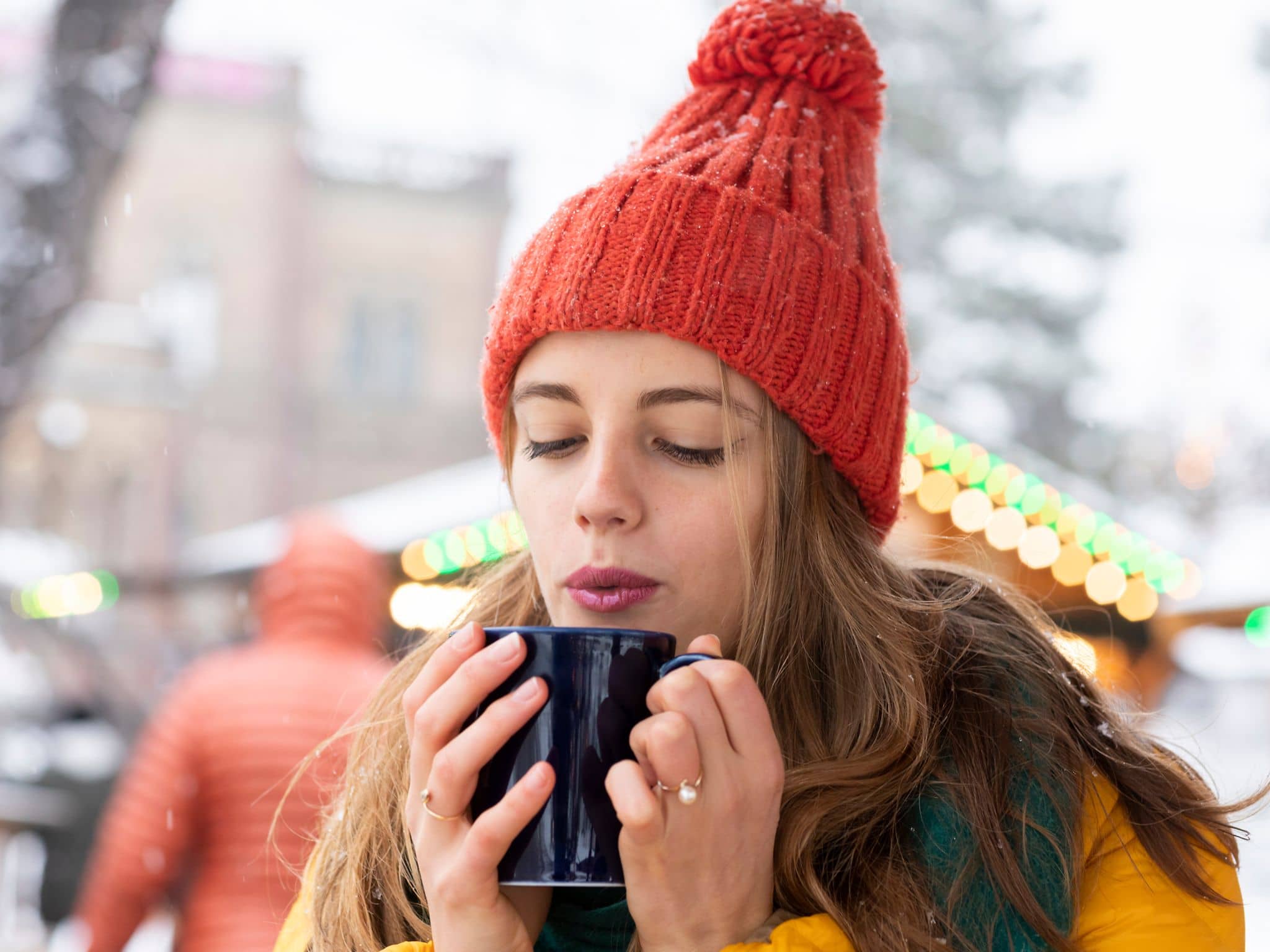 Gesund und lecker durch die Weihnachtszeit: Eine junge Frau genießt einen Glühwein