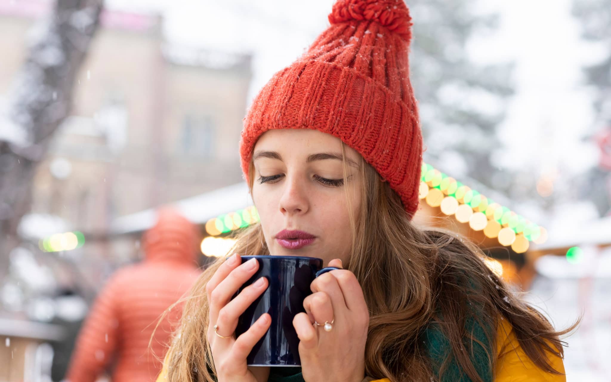 Gesund und lecker durch die Weihnachtszeit: Eine junge Frau genießt einen Glühwein