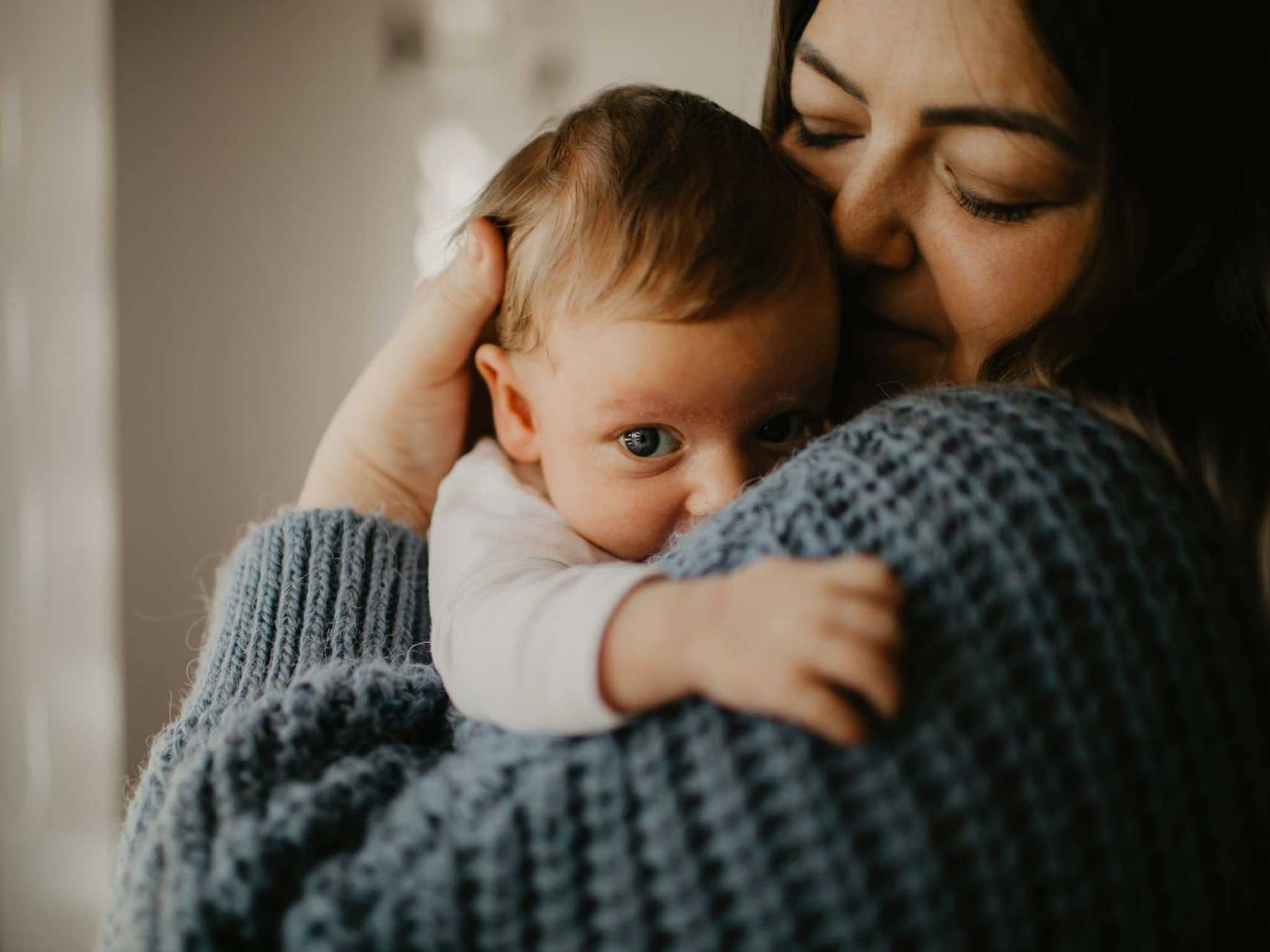 Frau hält liebevoll ihr Baby im Arm