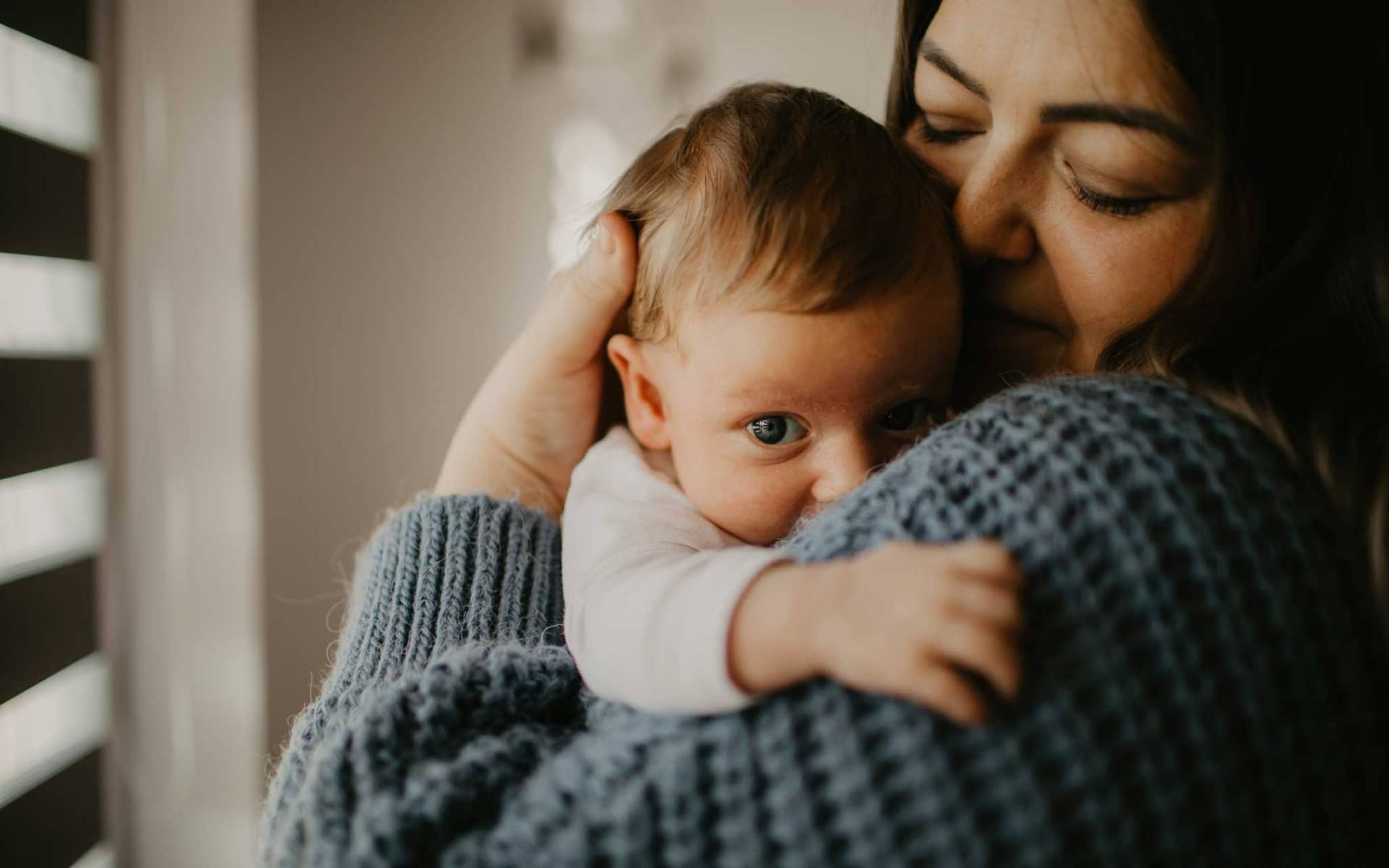 Frau hält liebevoll ihr Baby im Arm