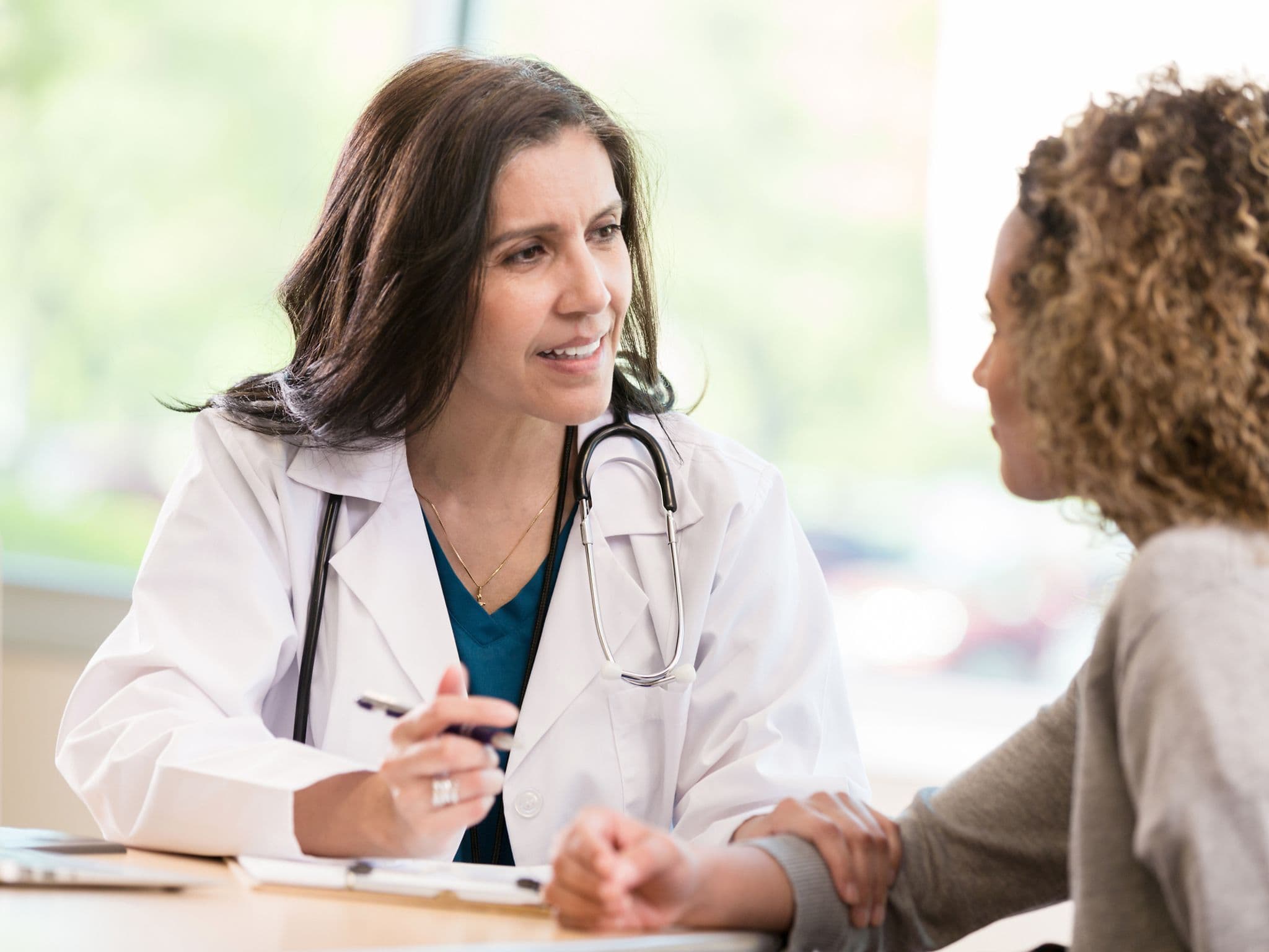 Vorbereitung Besuch bei Frauenärztin: Eine Gynäkologin im Gespräch mit einer Patientin