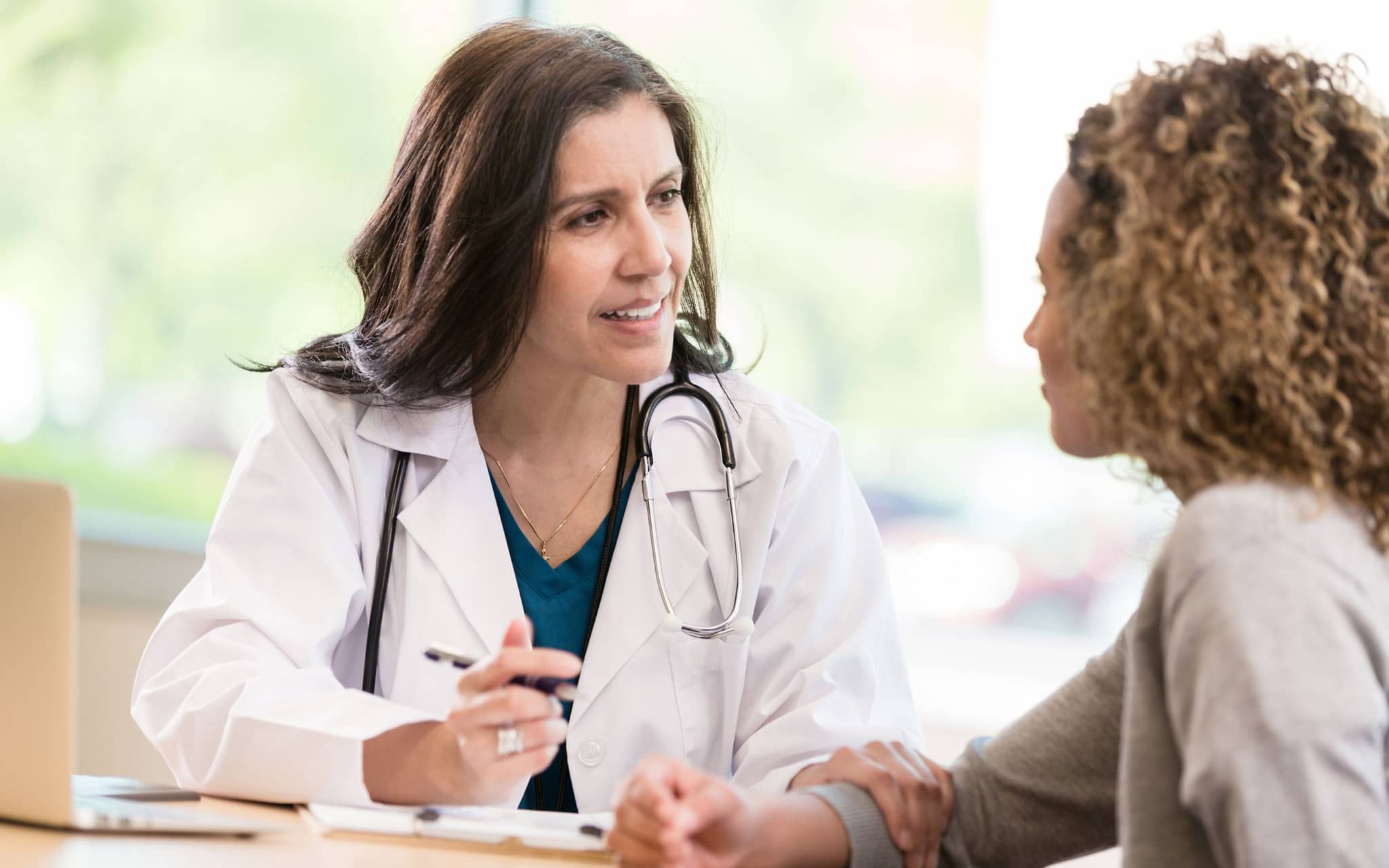 Vorbereitung Besuch bei Frauenärztin: Eine Gynäkologin im Gespräch mit einer Patientin