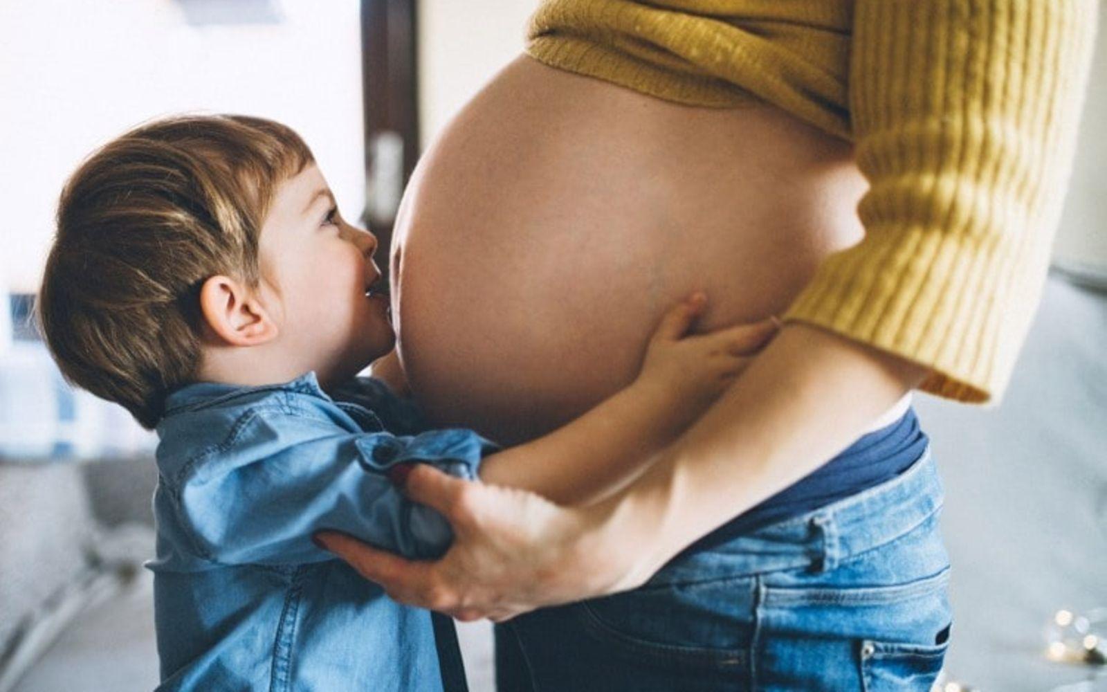 Rhesusfaktor-Untersuchung: Junge küsst Babybauch.