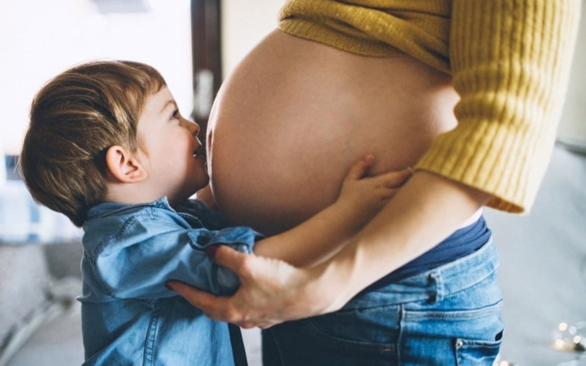 Rhesusfaktor-Untersuchung: Junge küsst Babybauch.