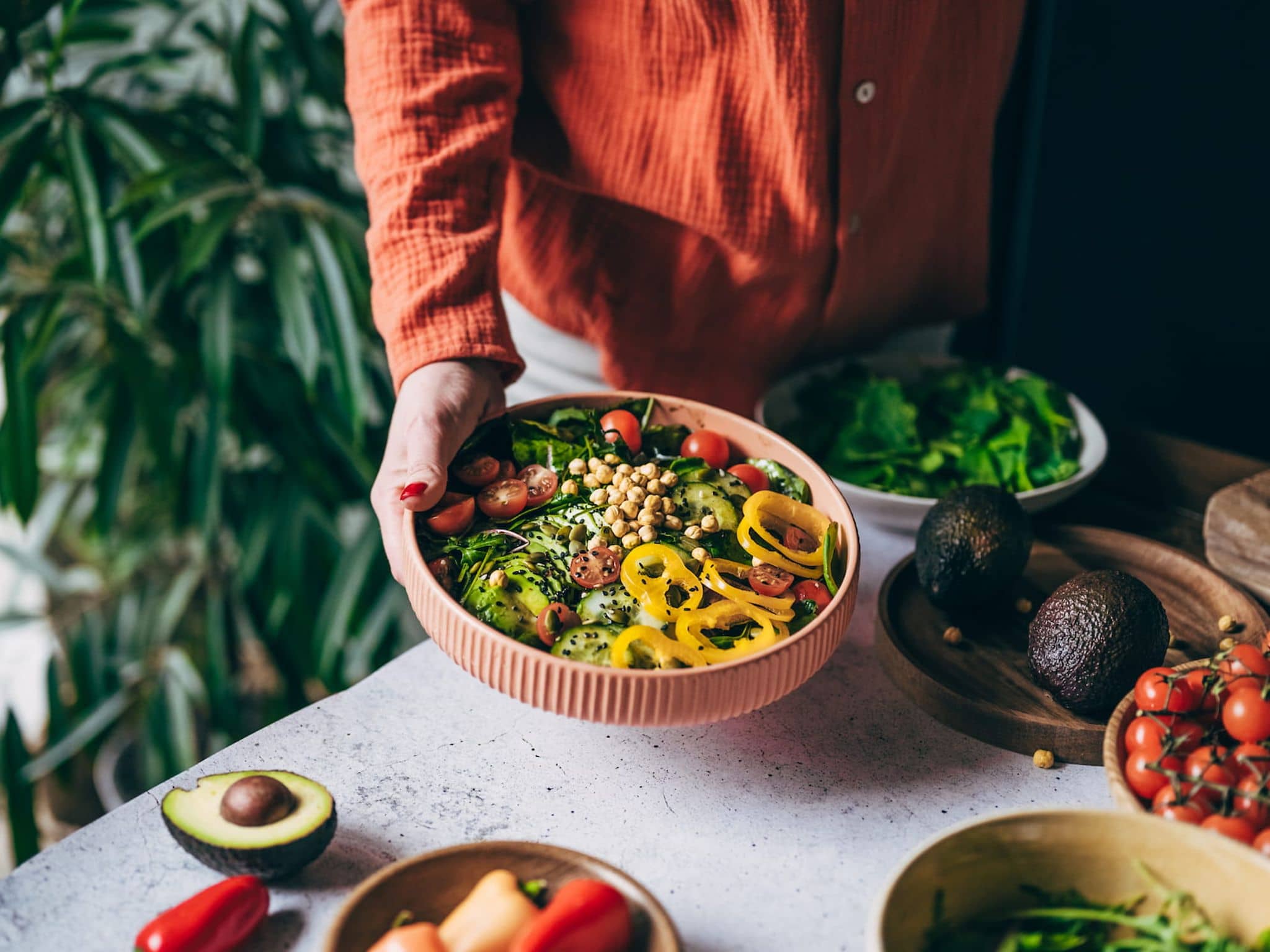 Frau hält eine Schüssel mit Gemüse und Kichererbsen