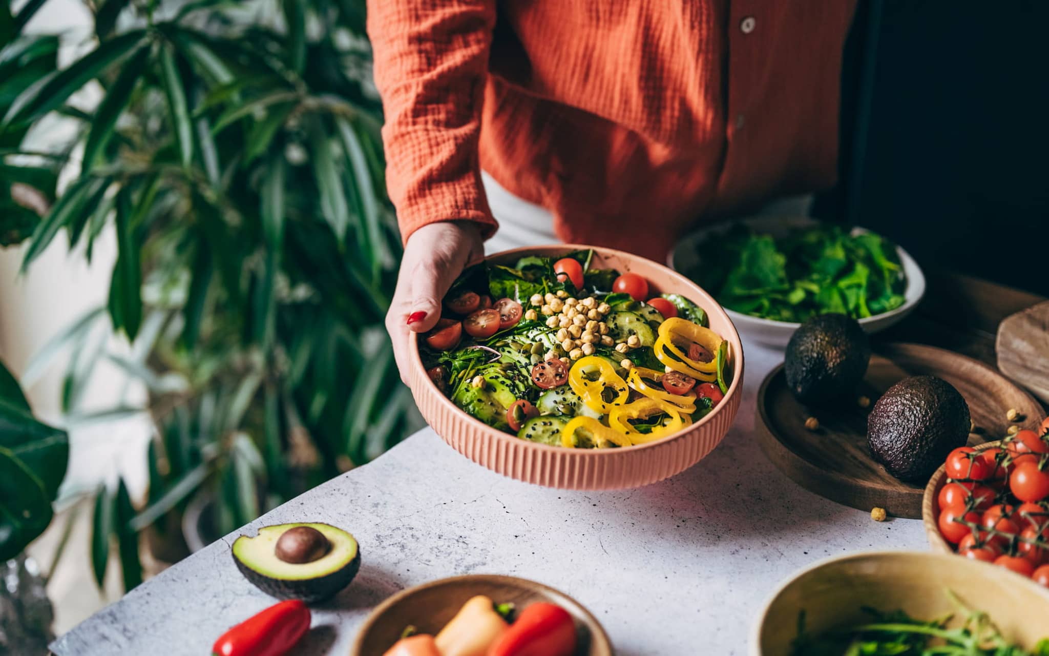 Frau hält eine Schüssel mit Gemüse und Kichererbsen