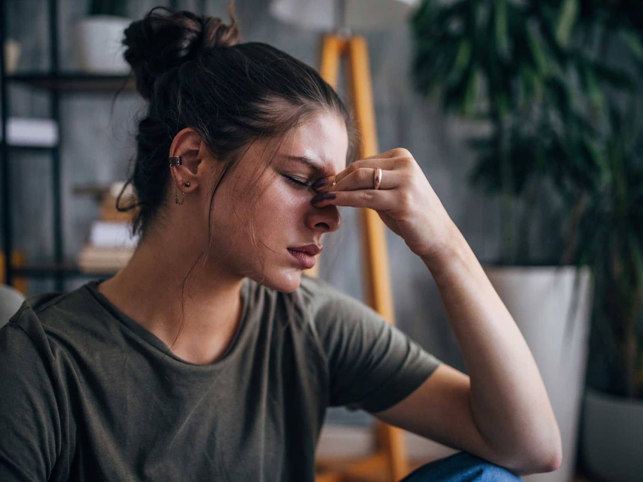 Frau leidet unter Kopfschmerzen und fasst sich an die Stirn