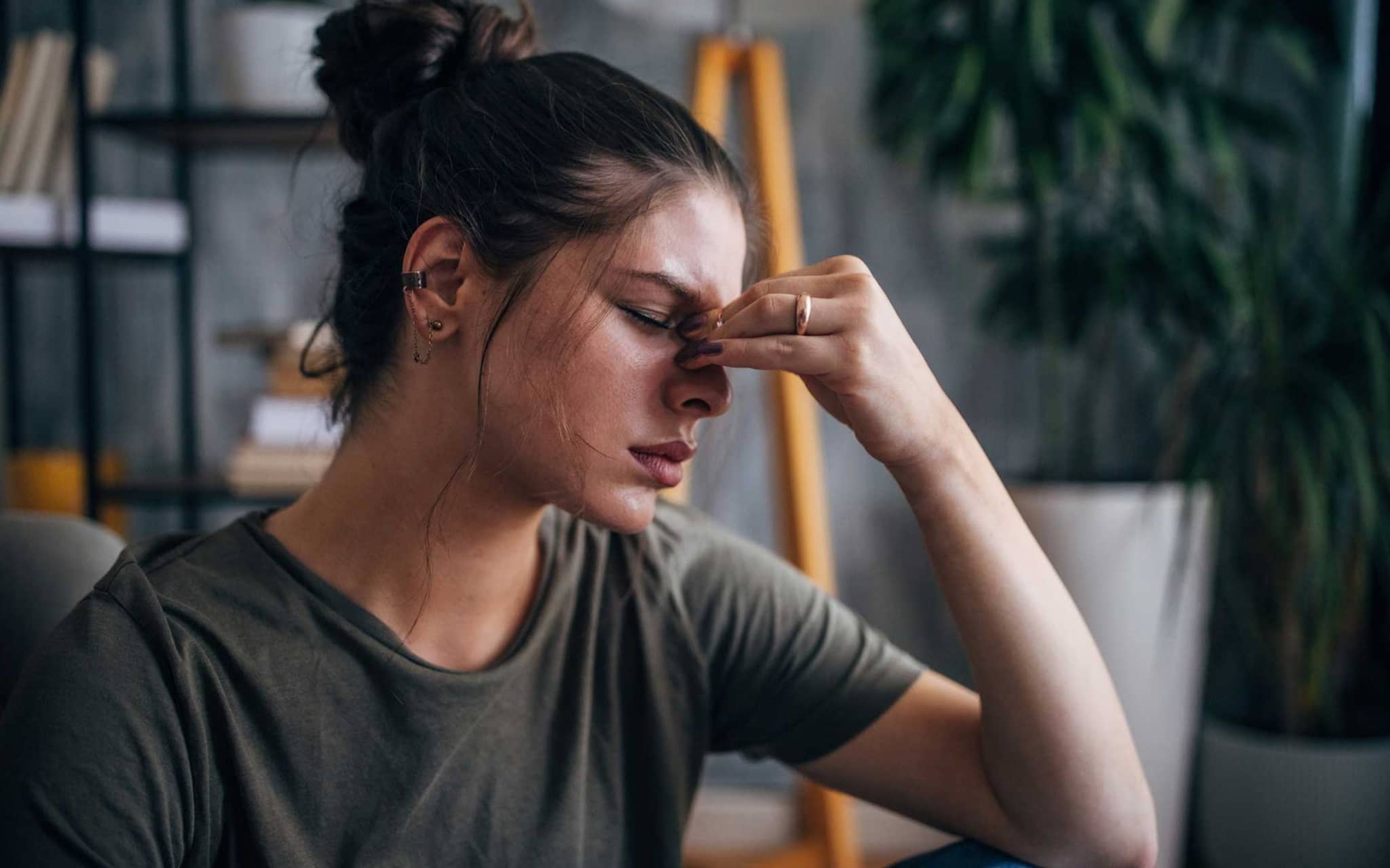 Frau leidet unter Kopfschmerzen und fasst sich an die Stirn