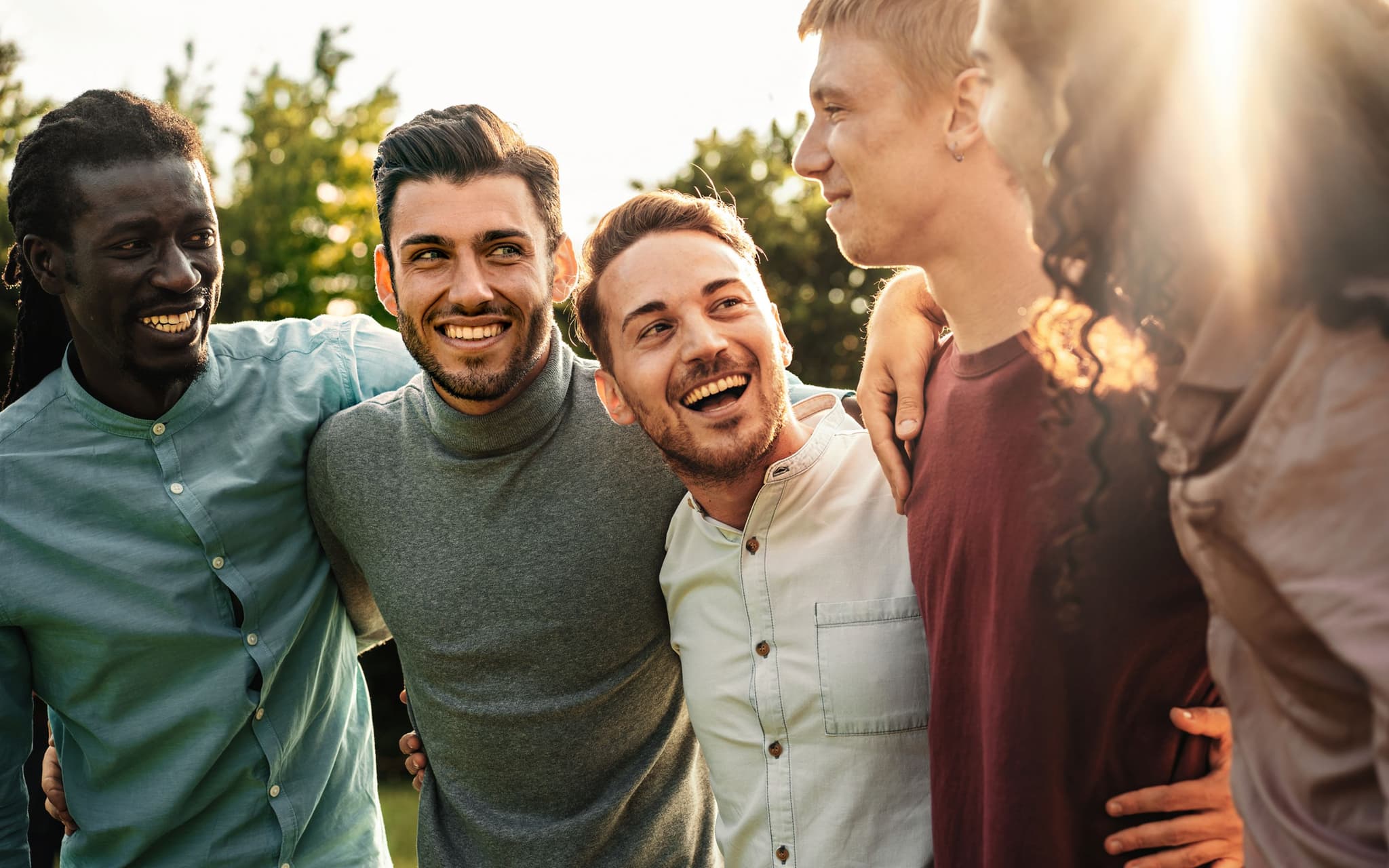 Toxic Positivity: Eine Gruppe junger Männer steht lachendend zusammen