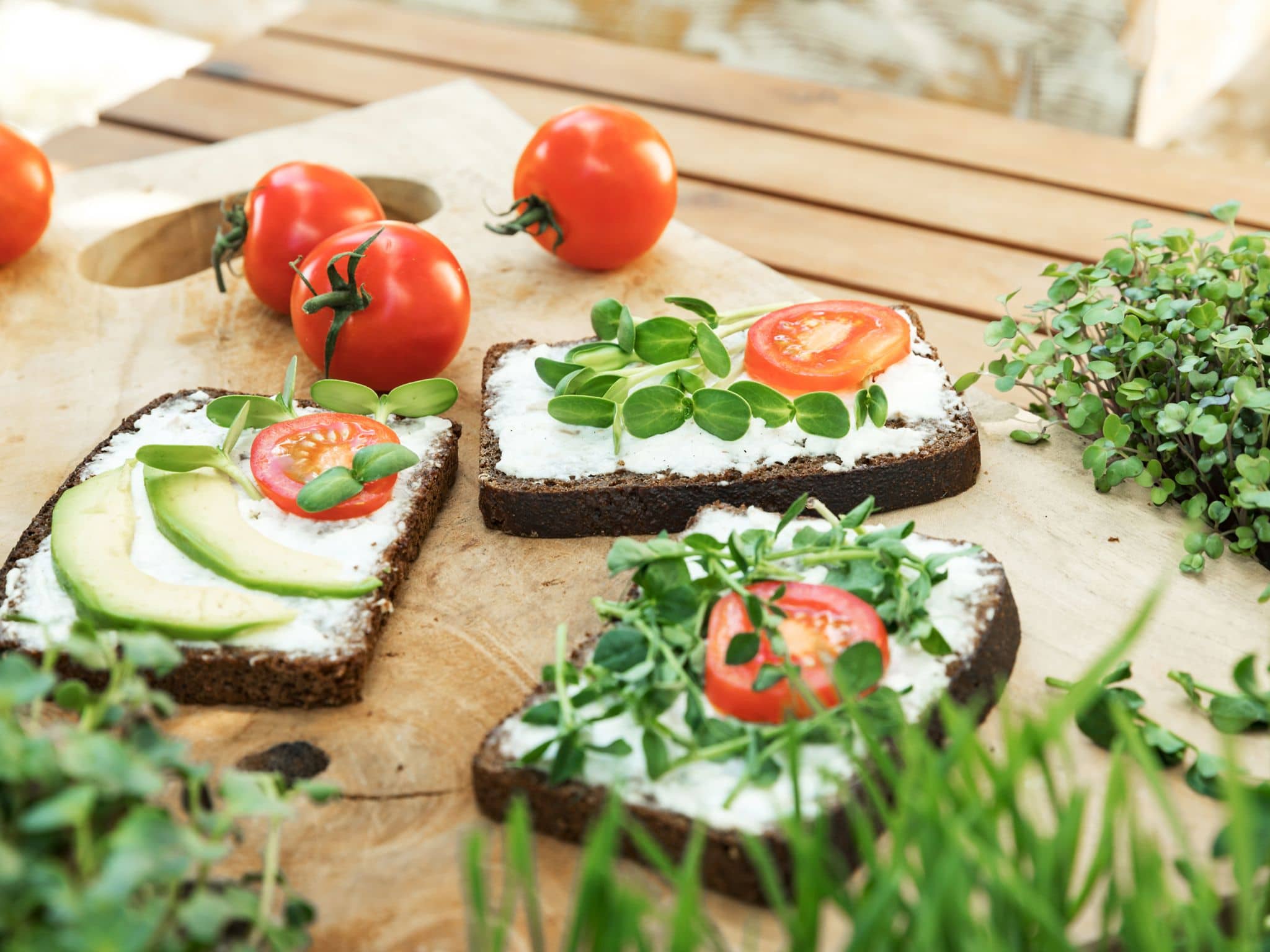 Gesundes Frühstück bestehend aus Vollkornbrot mit Quark, Gurken und Kräutern.